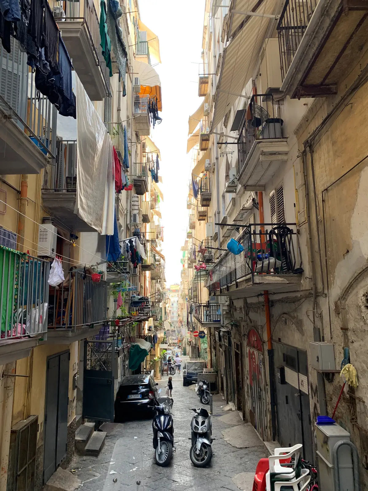 Scooters parked along a narrow street in the Spanish Quarter of Naples