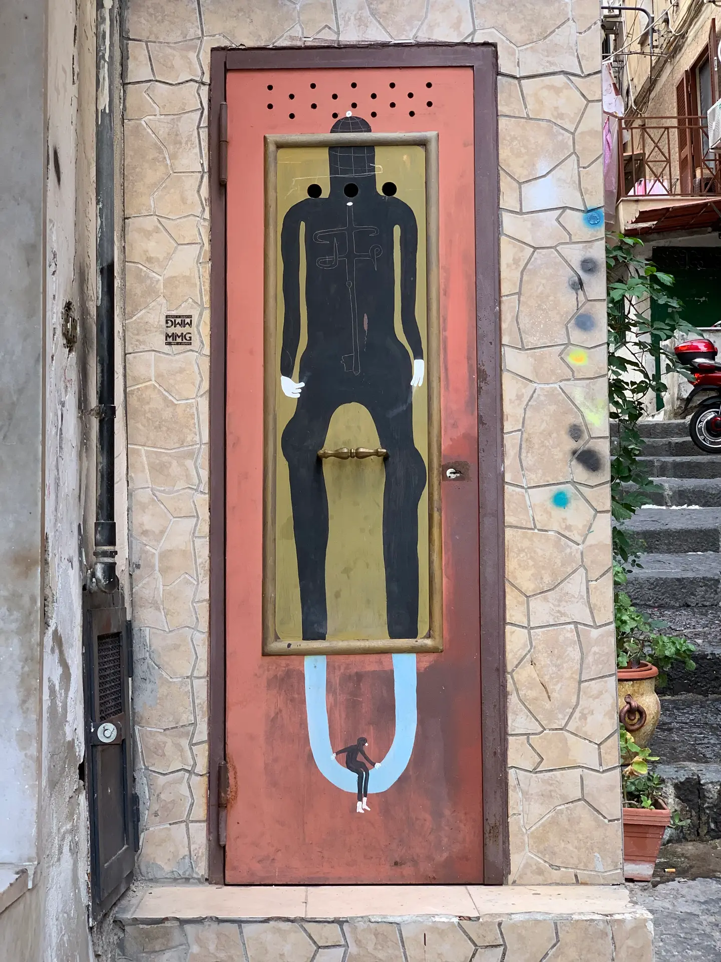 A painted figure on a red doorway in the Spanish Quarter of Naples