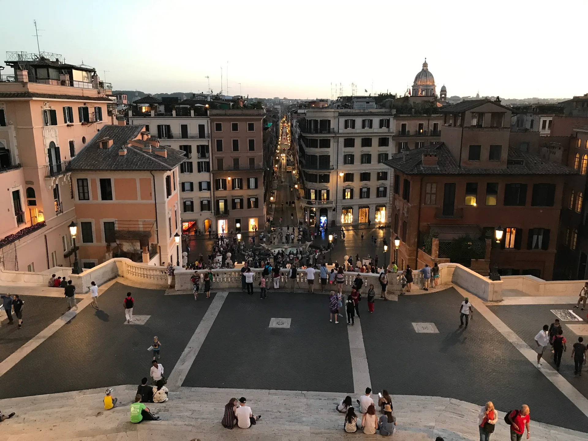 Dusk view from the top of the Spanish Steps over the lamplit piazza.