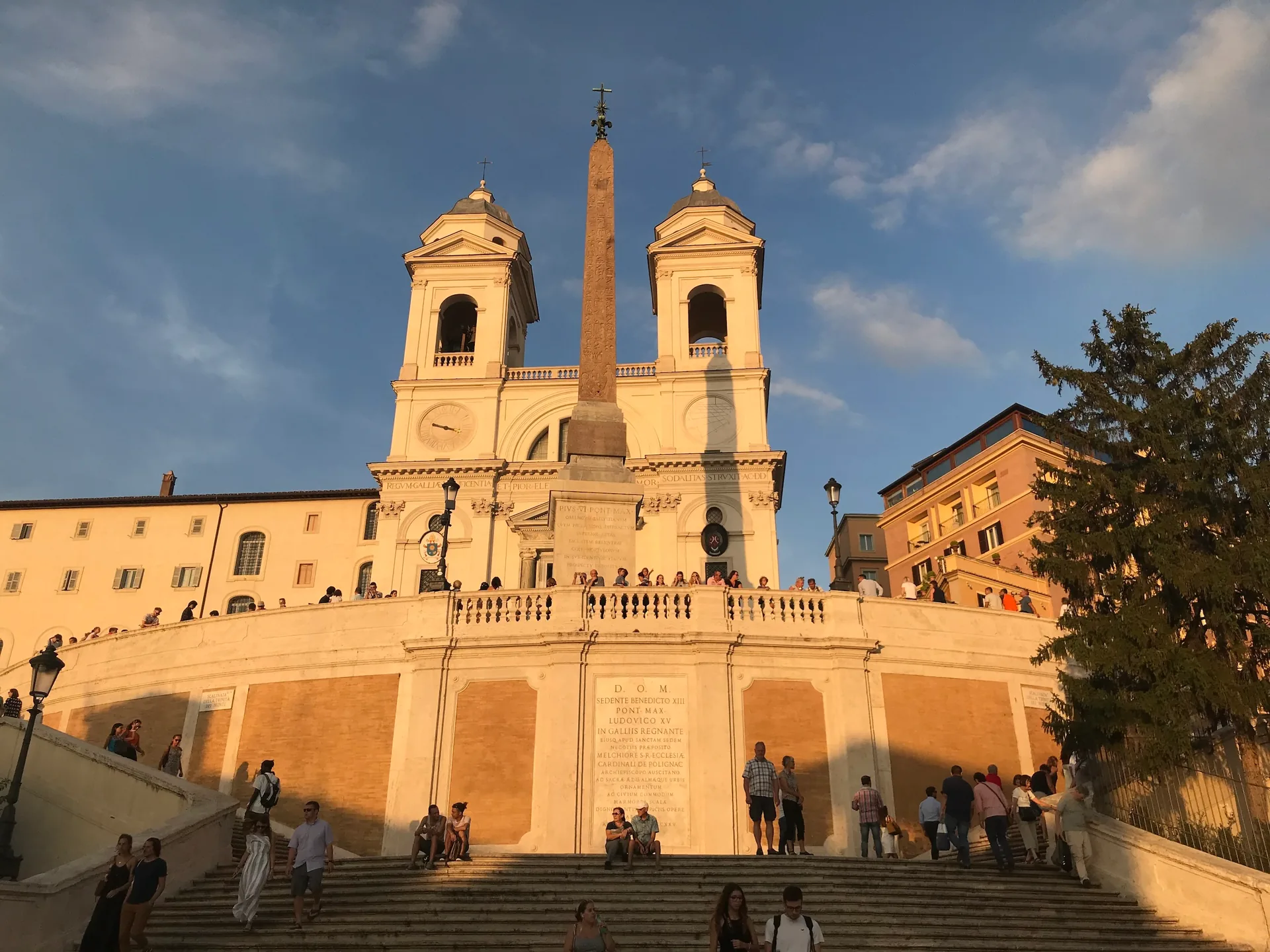 Trinità dei Monti church glowing in golden evening light above the steps.