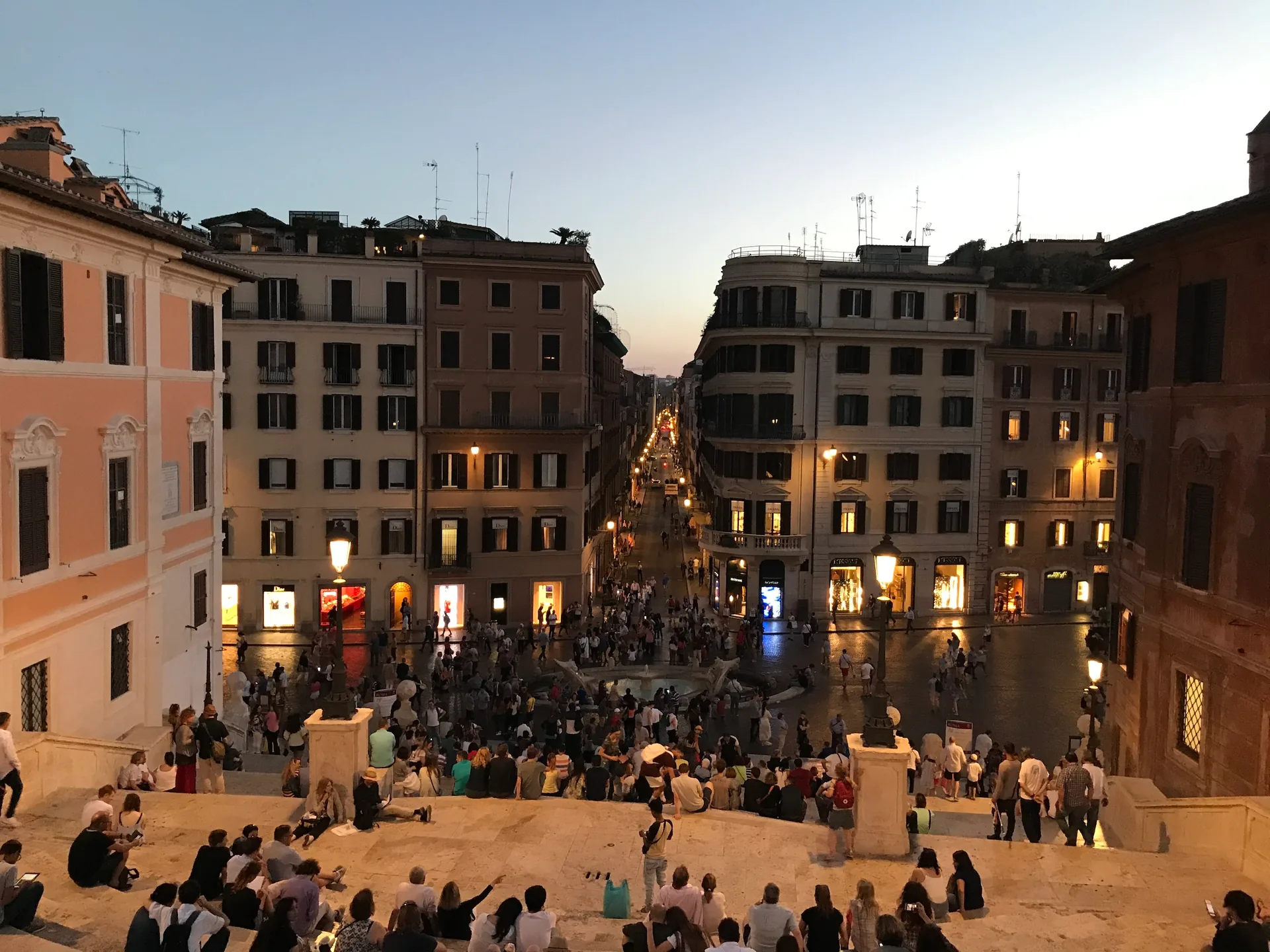 People gathered on the Spanish Steps at dusk looking over the piazza.