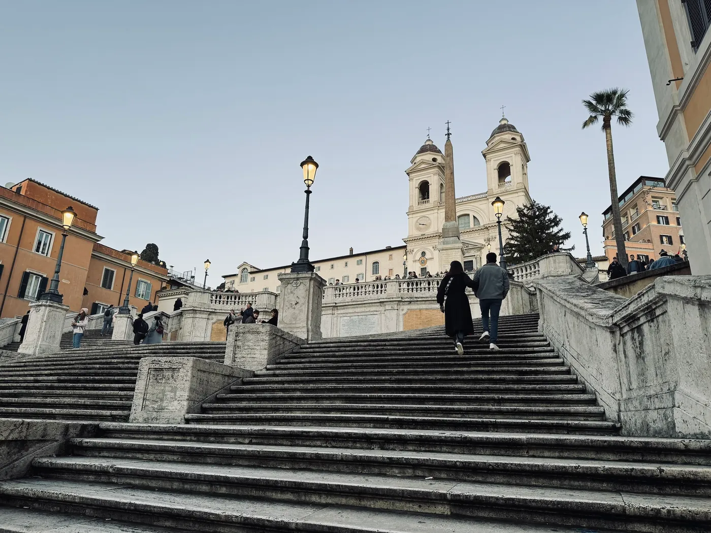 Nearly empty Spanish Steps at dusk in winter, lamps lit, the church above.