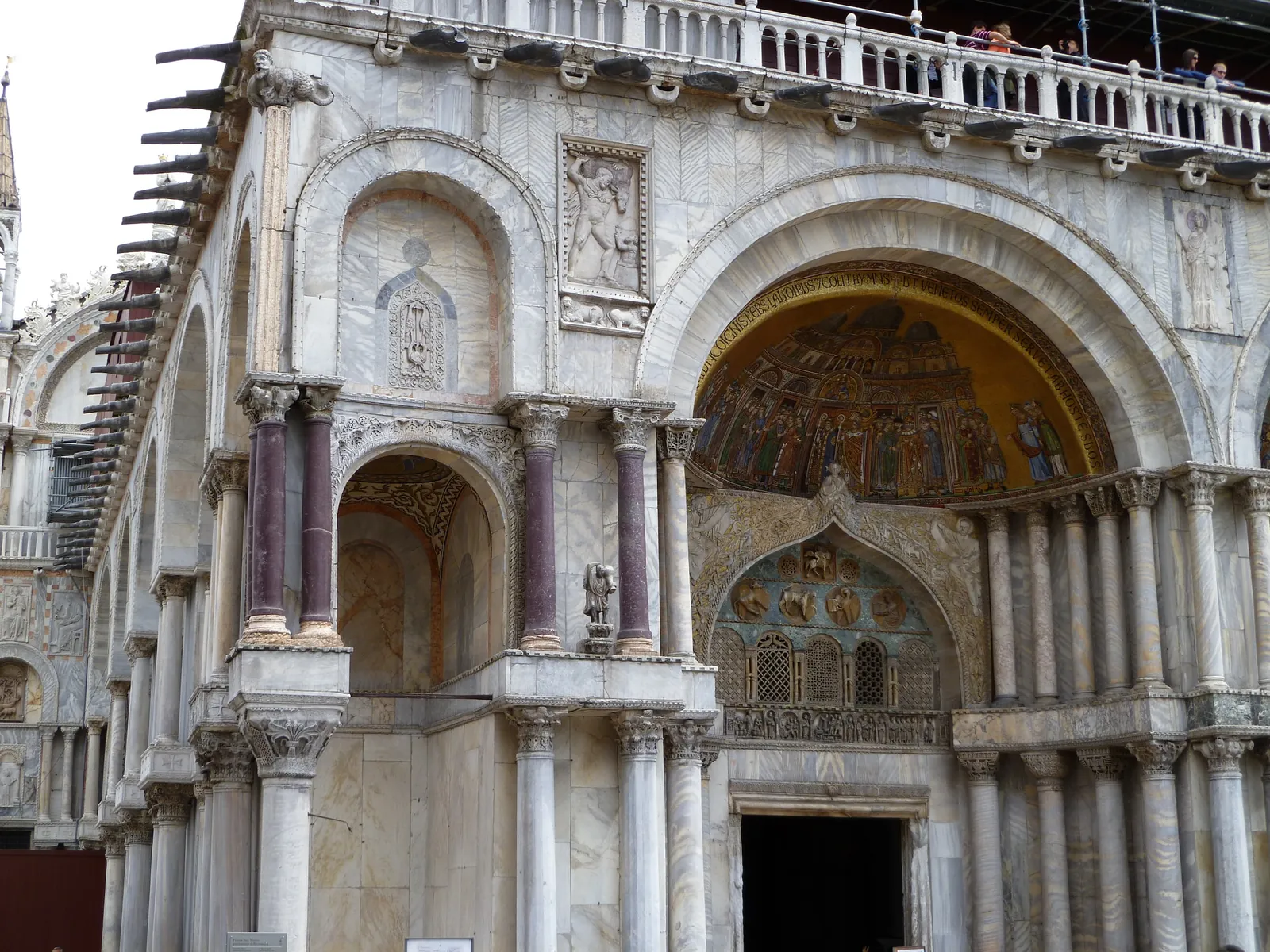 A portal of St Mark's Basilica framed by marble columns and Byzantine carving