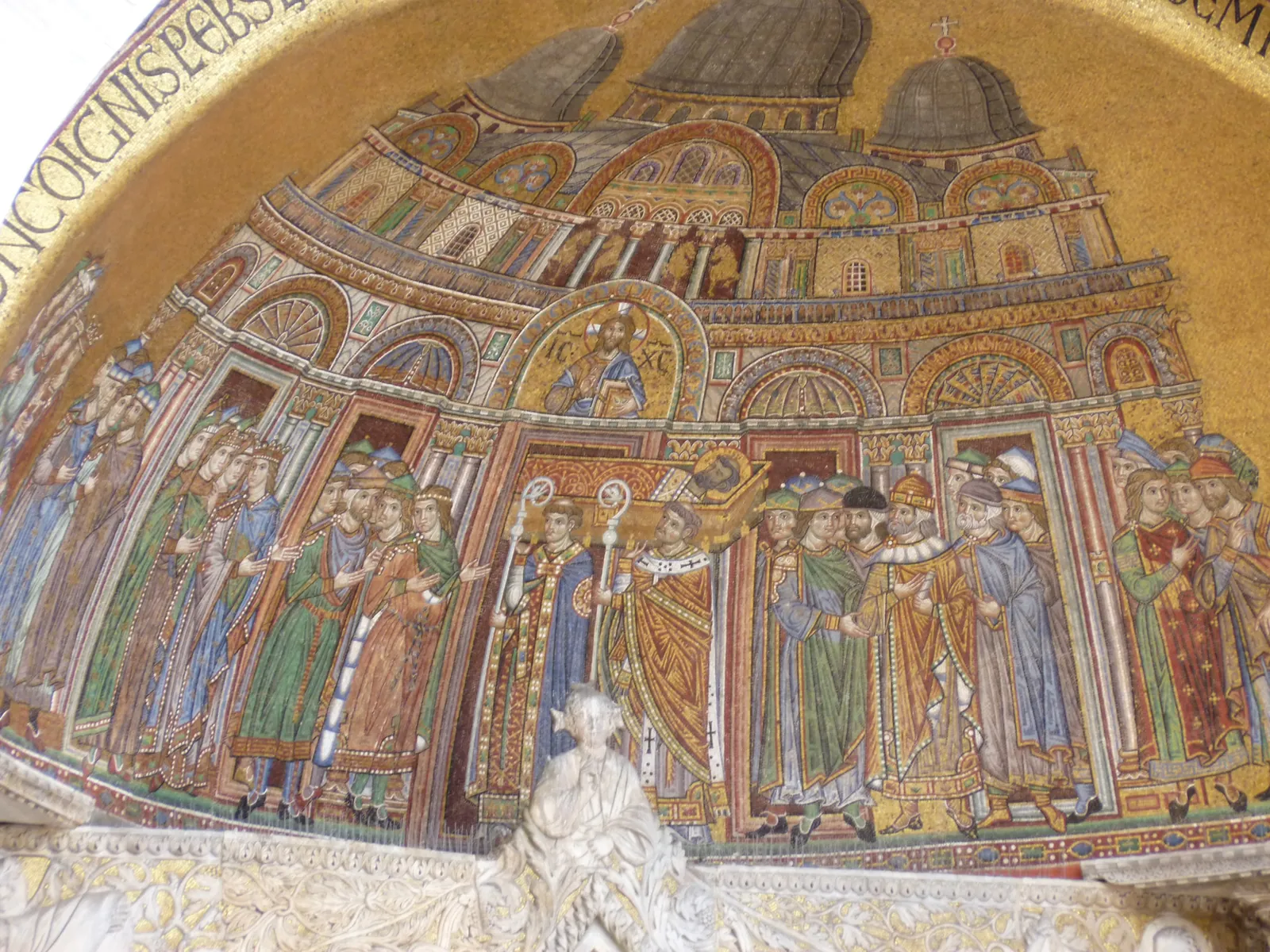 Golden Byzantine mosaic on the facade of St Mark's showing robed figures on a gold ground
