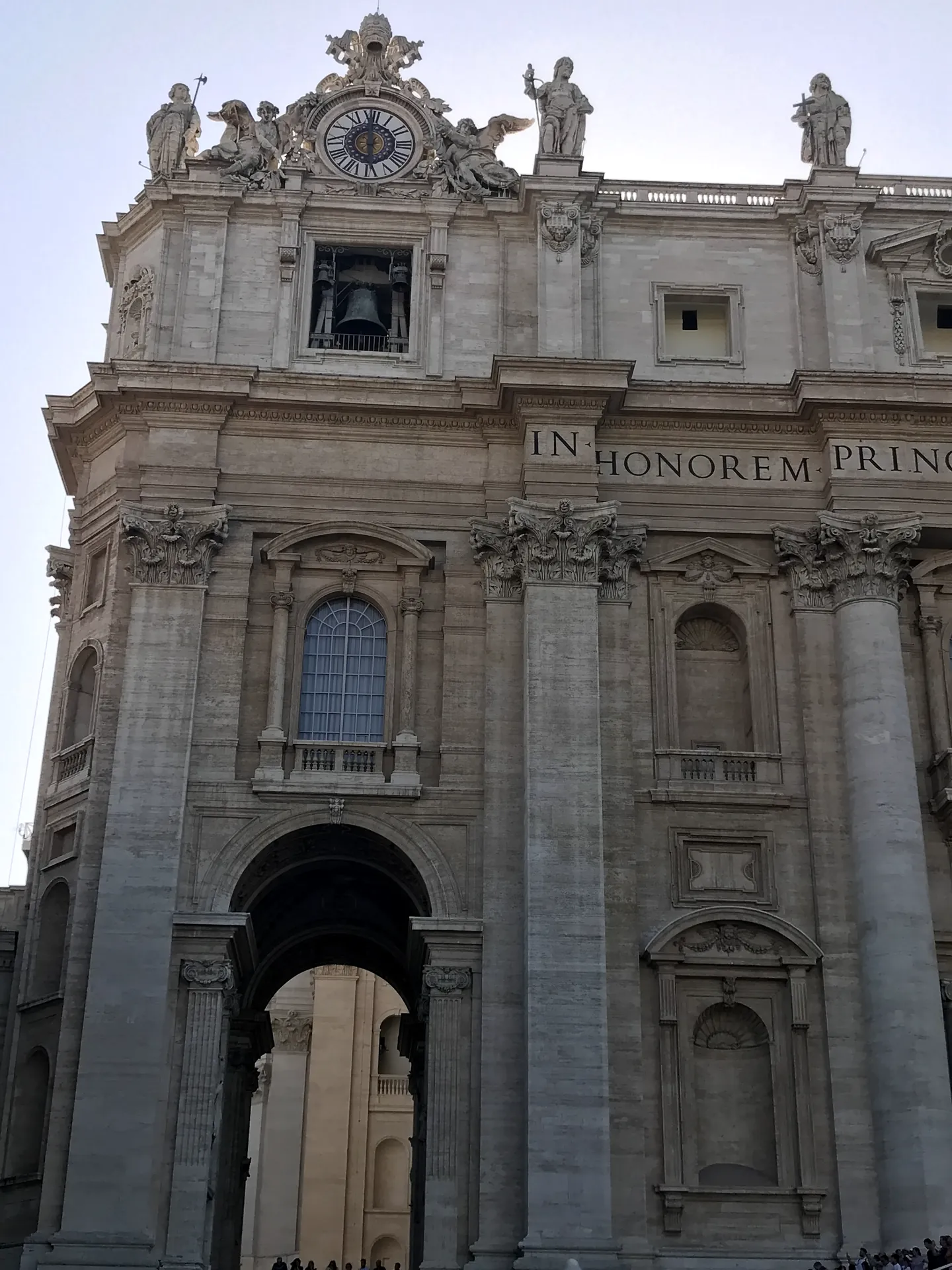 The travertine facade of St. Peter's Basilica with its rooftop statues