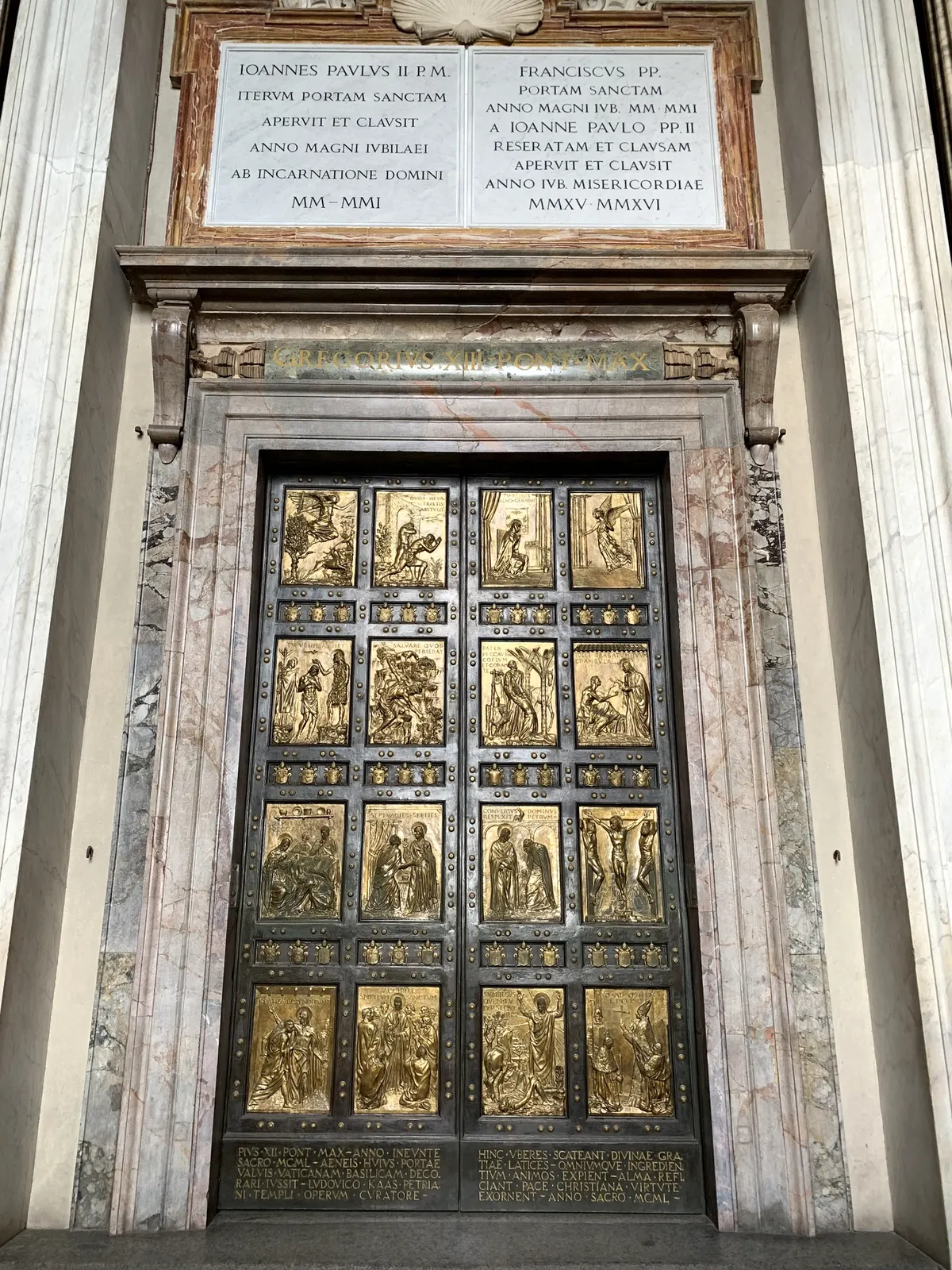 The bronze gilded Holy Door of St. Peter's Basilica with relief panels