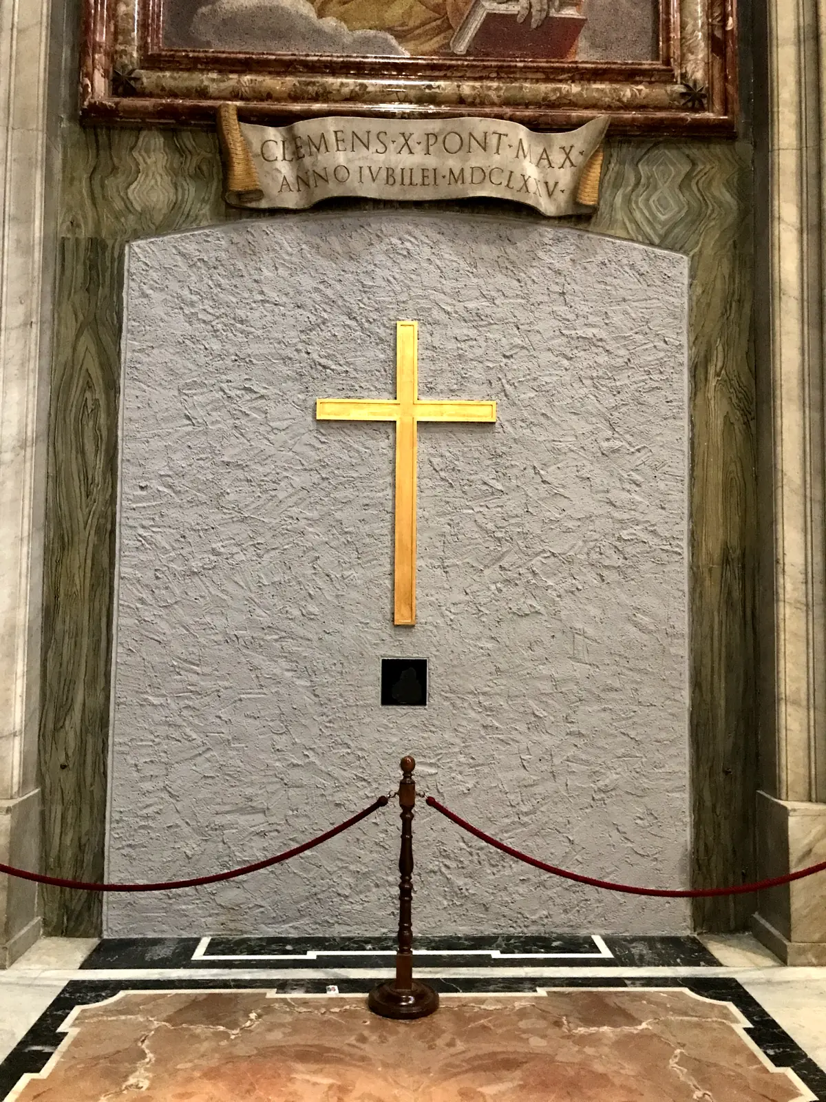 The tomb of St. John Paul II, a marble slab with a gilded cross