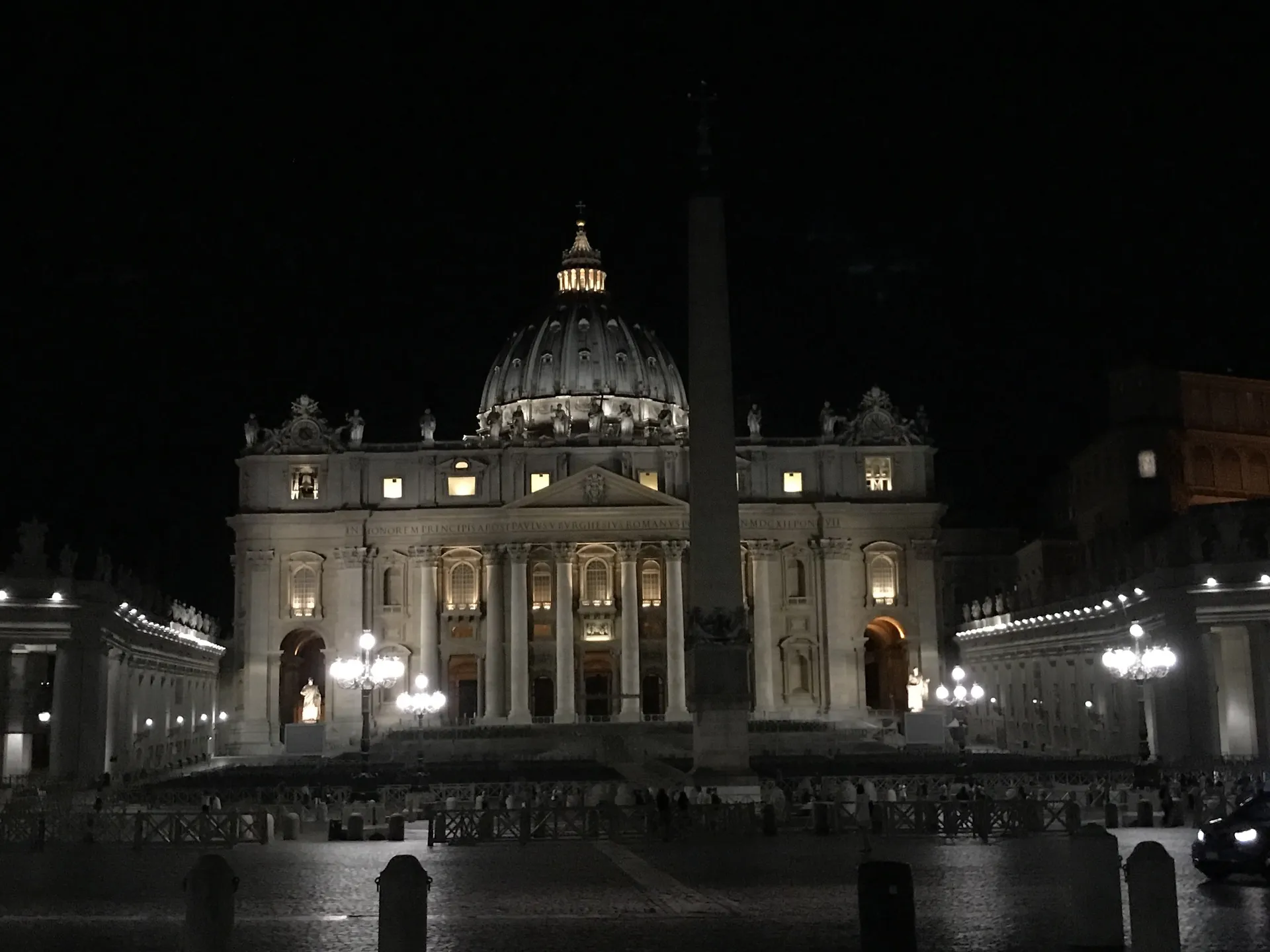 St. Peter's Basilica floodlit at night above an empty square