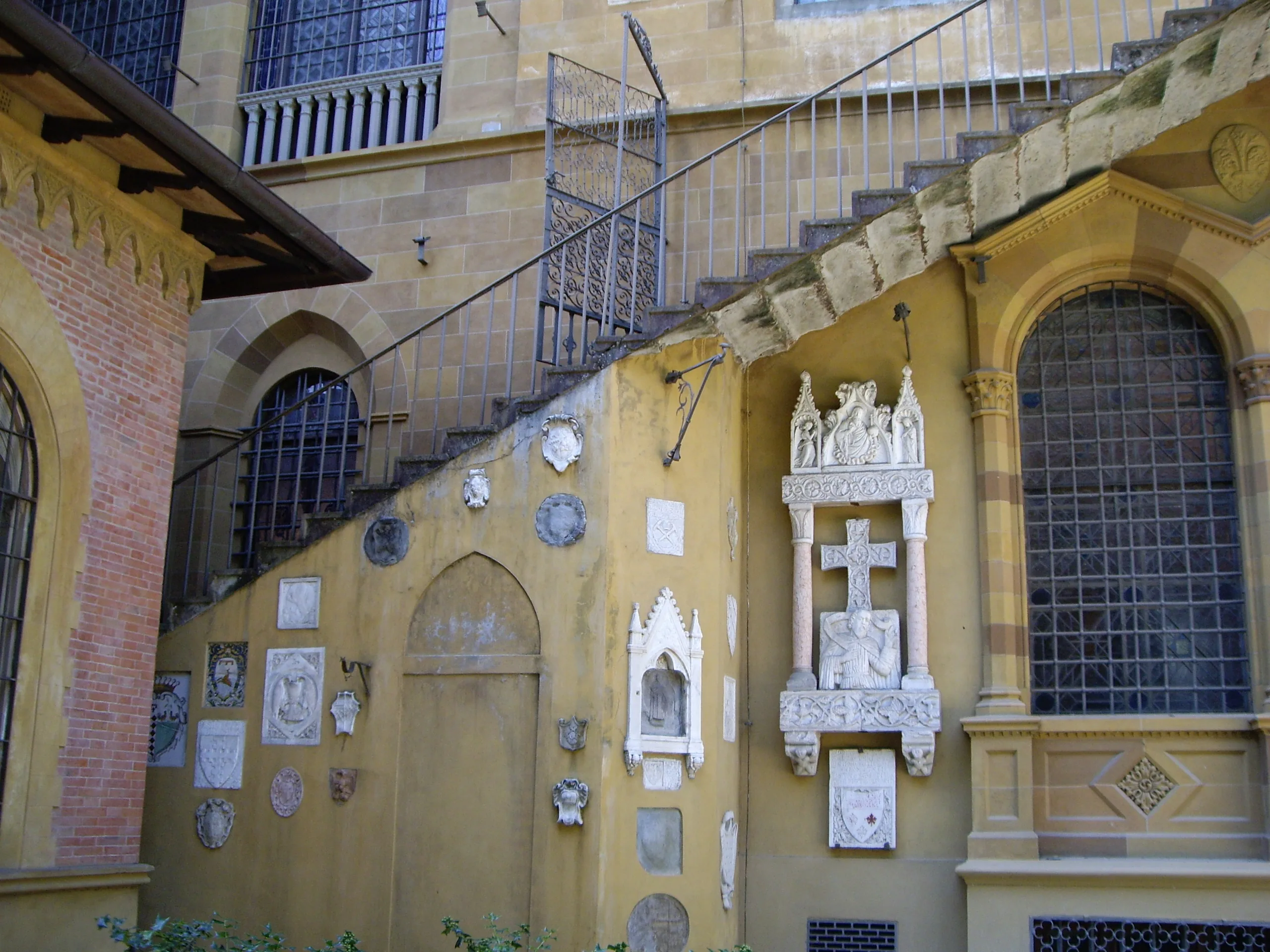 A carved Gothic tabernacle and a crowd of marble plaques set into the villa wall