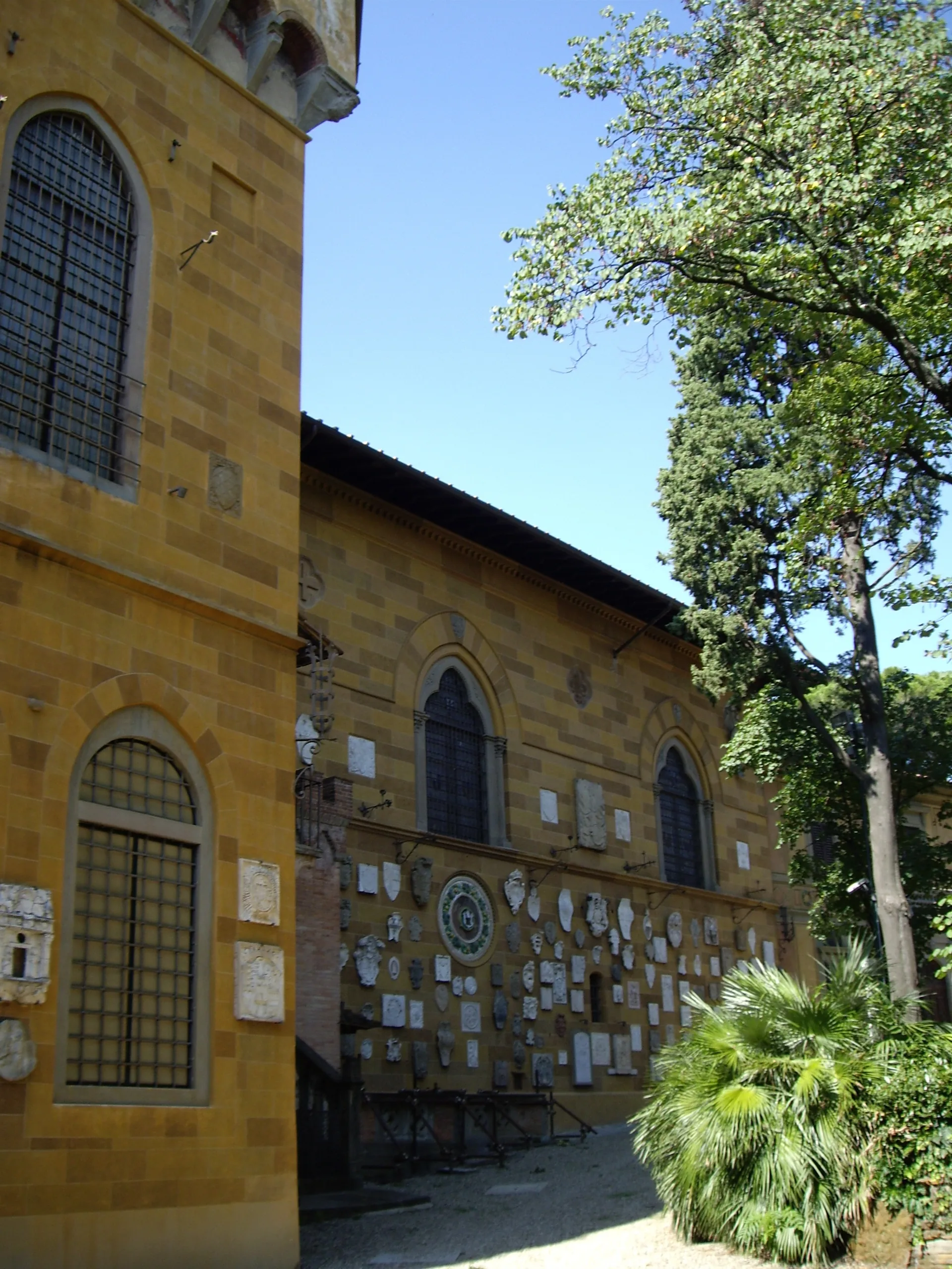 A wing of the Villa Stibbert with its plaque-covered wall and the park pressing up against it