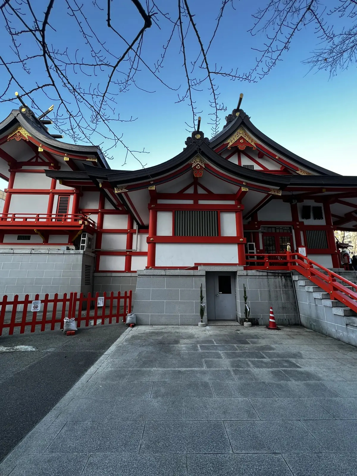 Vermilion Shinto shrine with a red railing on a clear winter day in Tokyo