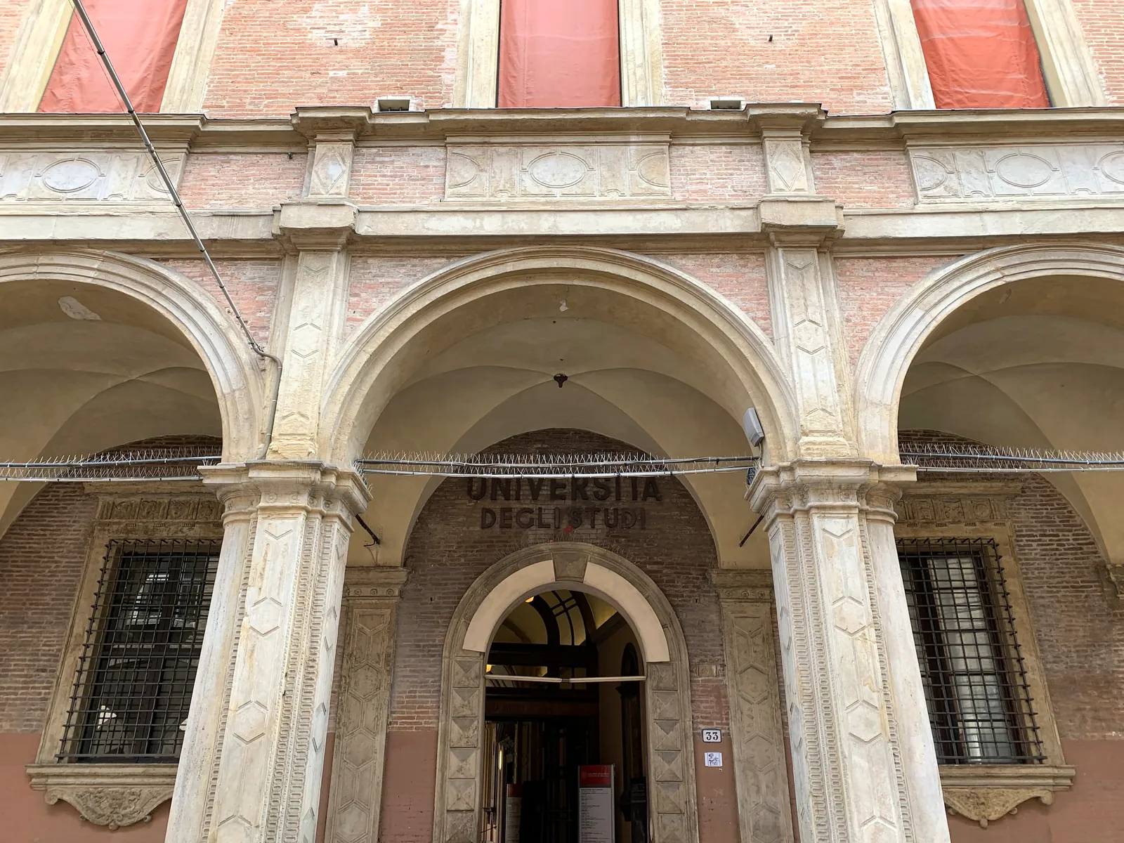The arcaded Universita degli Studi facade on Via Zamboni in Bologna.
