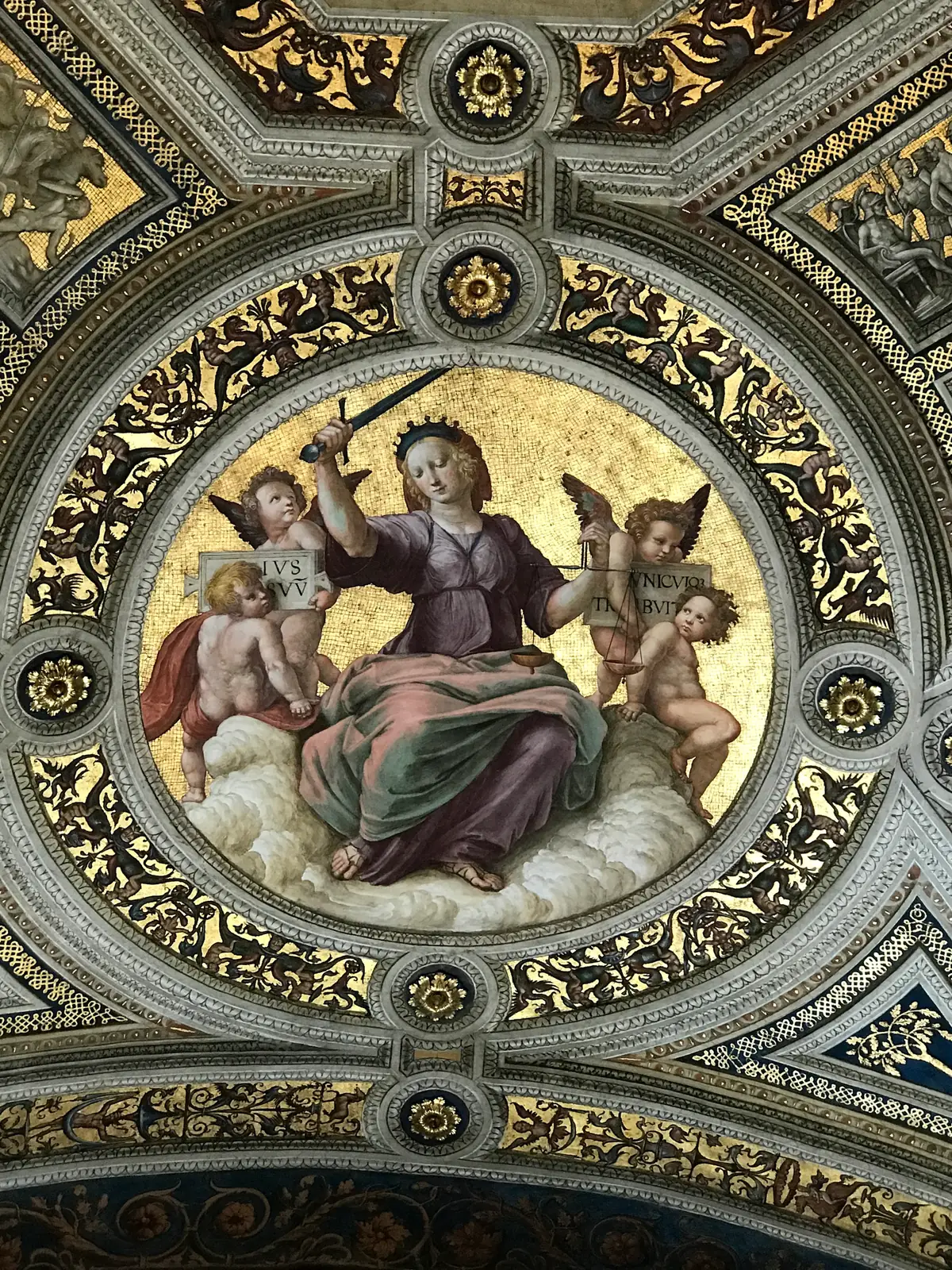 Ceiling roundel of Justice holding scales above the School of Athens in the Raphael Rooms.