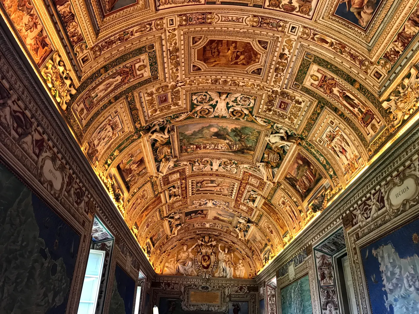 The long barrel-vaulted corridor of the Vatican Gallery of Maps receding into the distance.