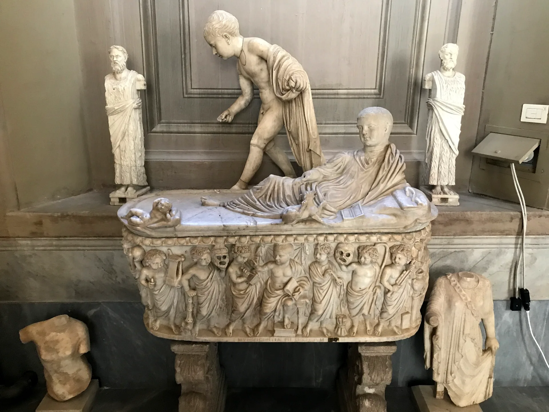 Roman marble sarcophagus with a reclining portrait of the deceased carved on its lid.