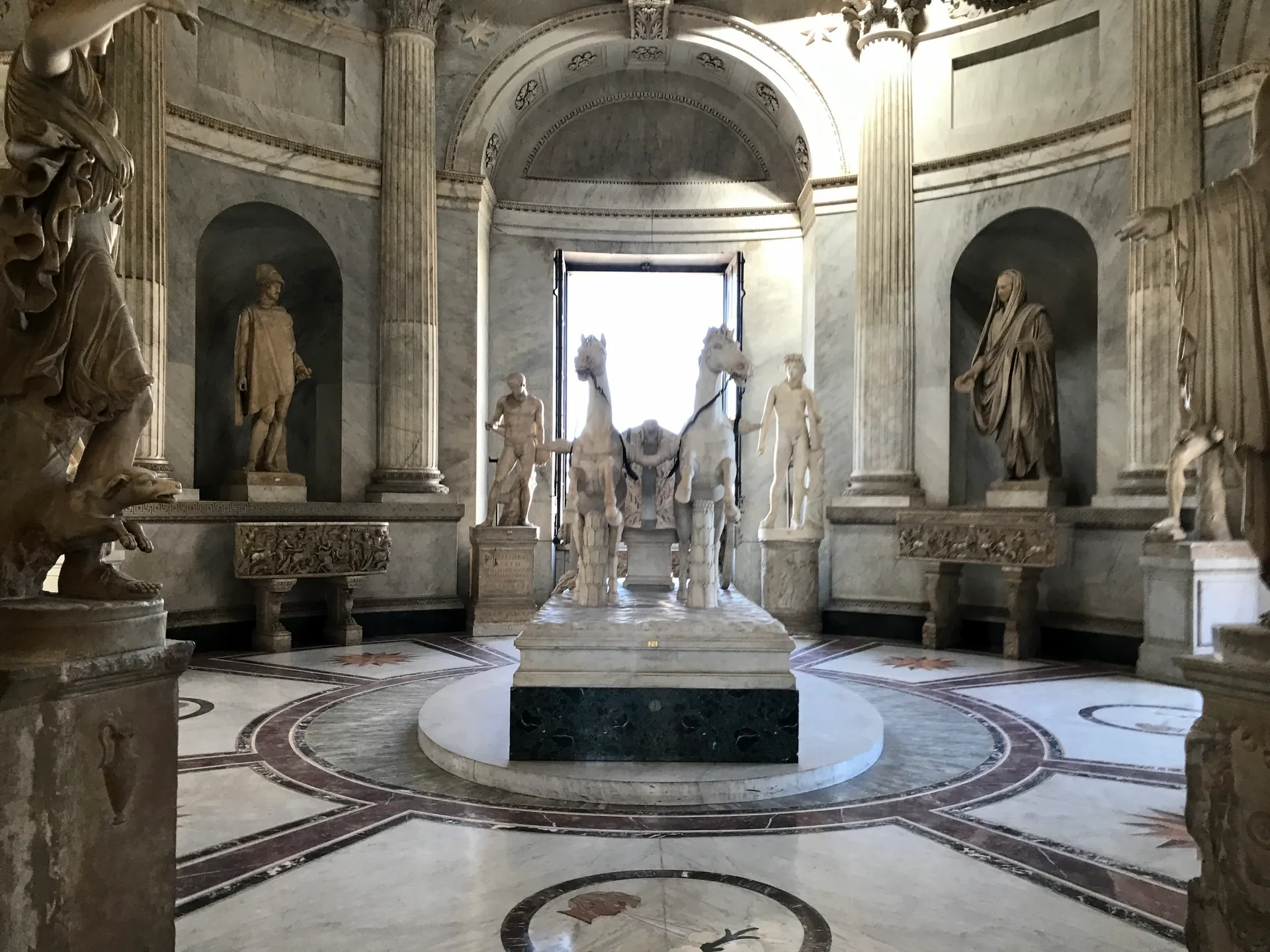 The domed Sala della Biga in the Vatican Museums with the marble two-horse chariot at its center.