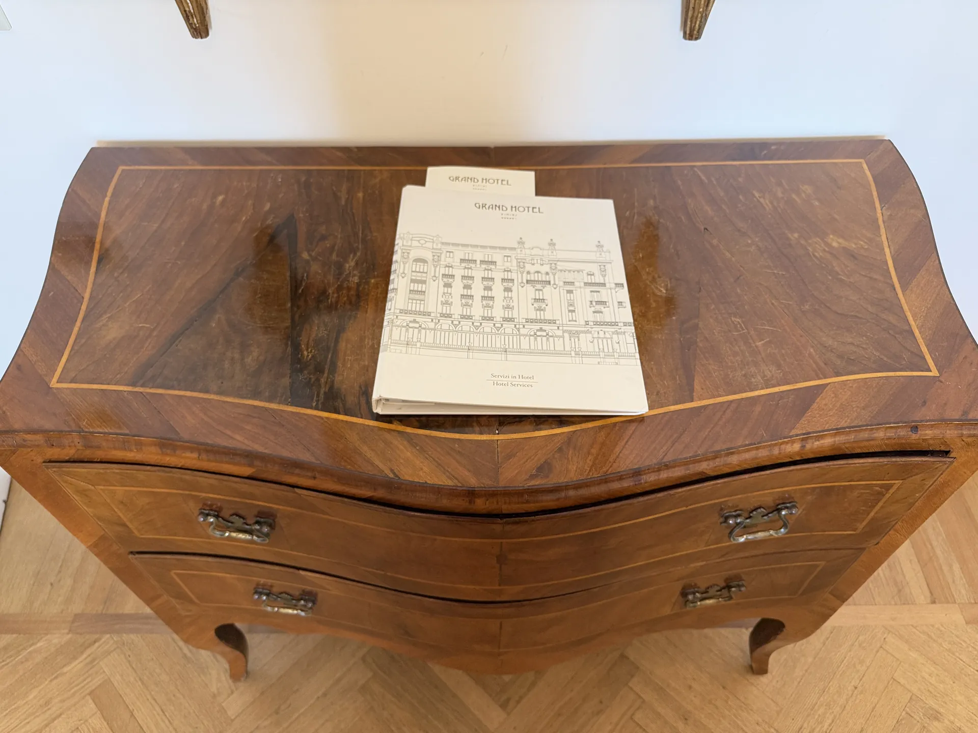 Inlaid walnut bureau in a hotel room with the hotel's own headed paper on the slope