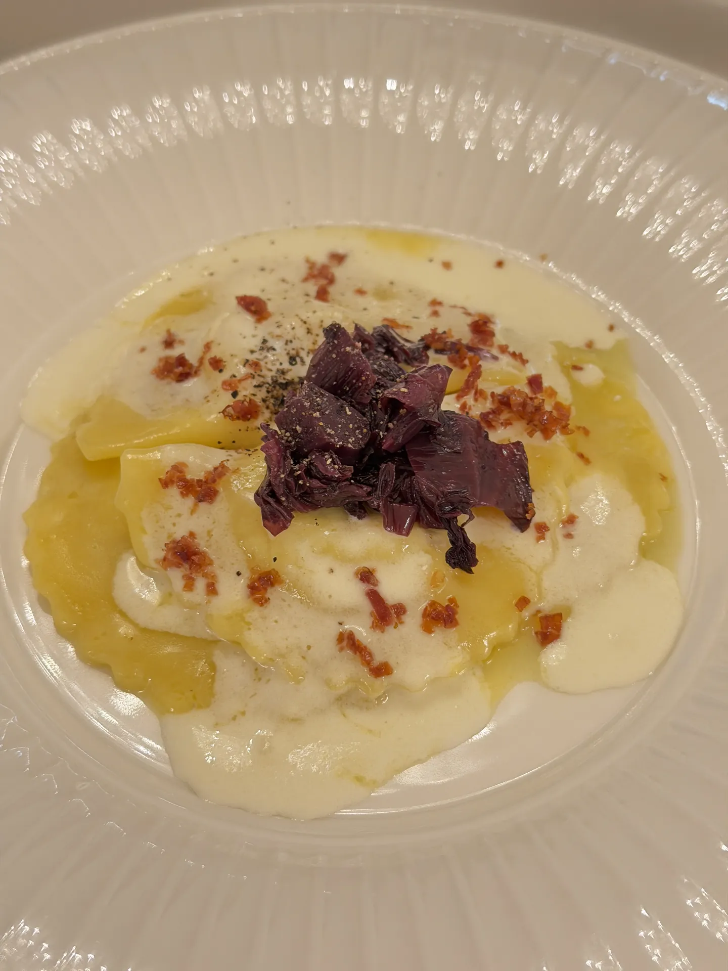 Radicchio panzerotti with leek cream, speck and black pepper
