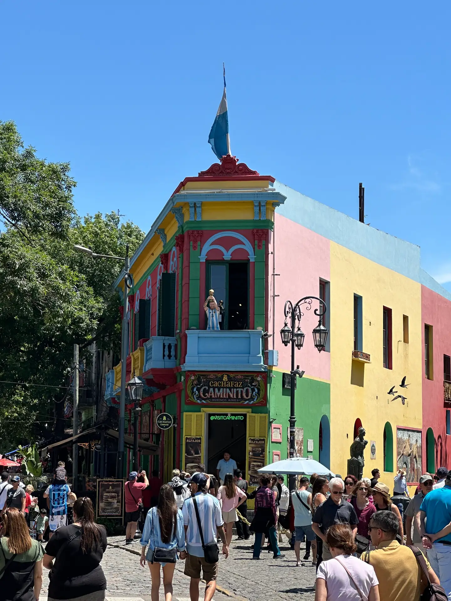 A brightly painted corner building at Caminito with an Argentine flag, La Boca.