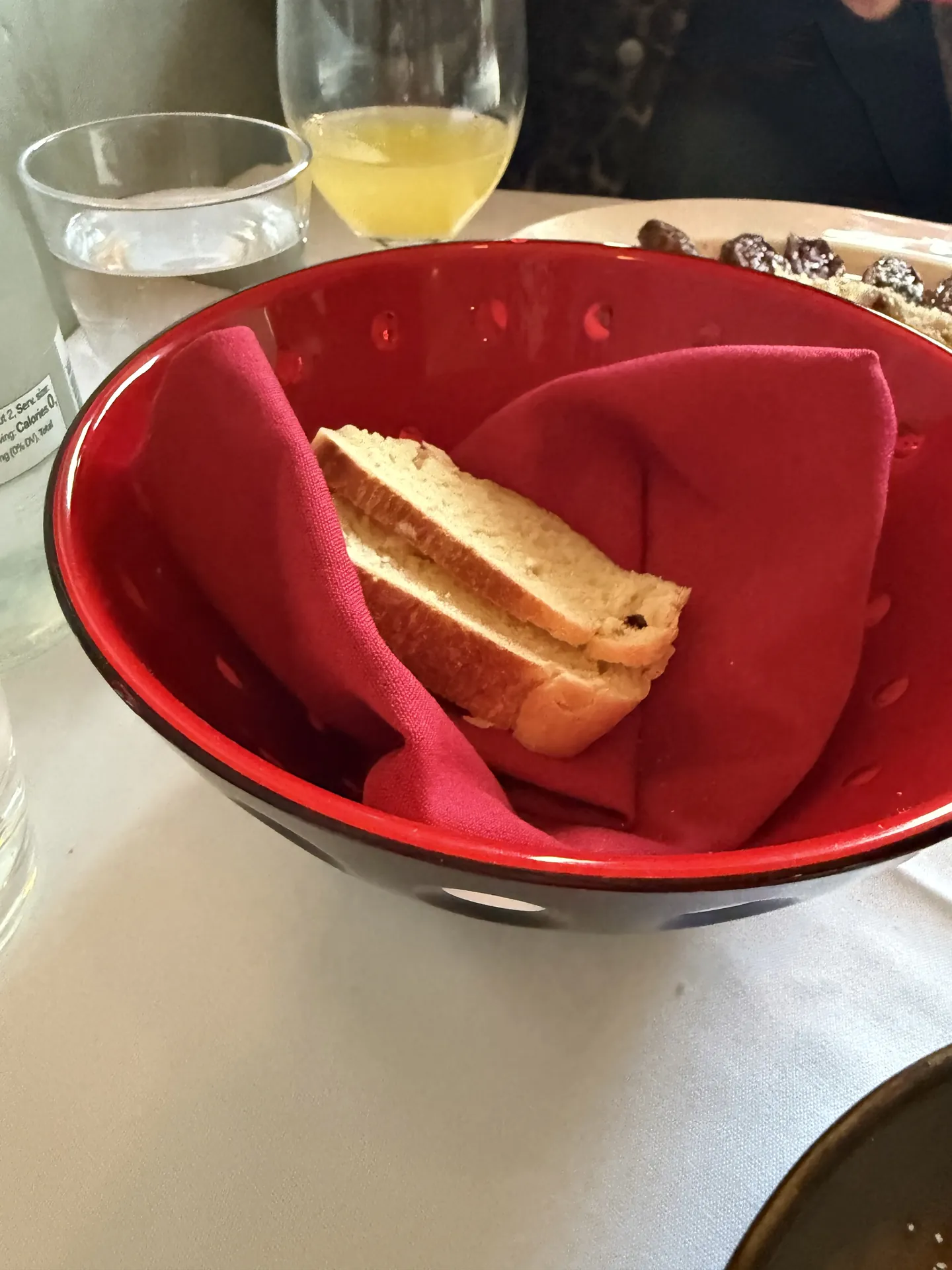 Sliced bread in a red napkin lined bowl.