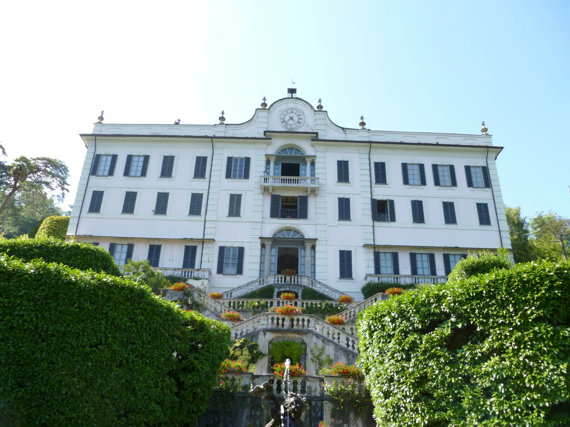 The white facade and clock of Villa Carlotta above its terraced garden at Tremezzo.