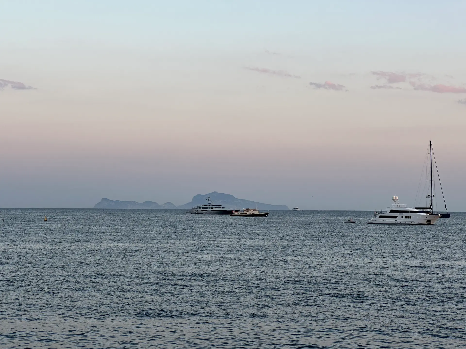The island of Capri on the horizon at sunset seen from the Naples seafront.