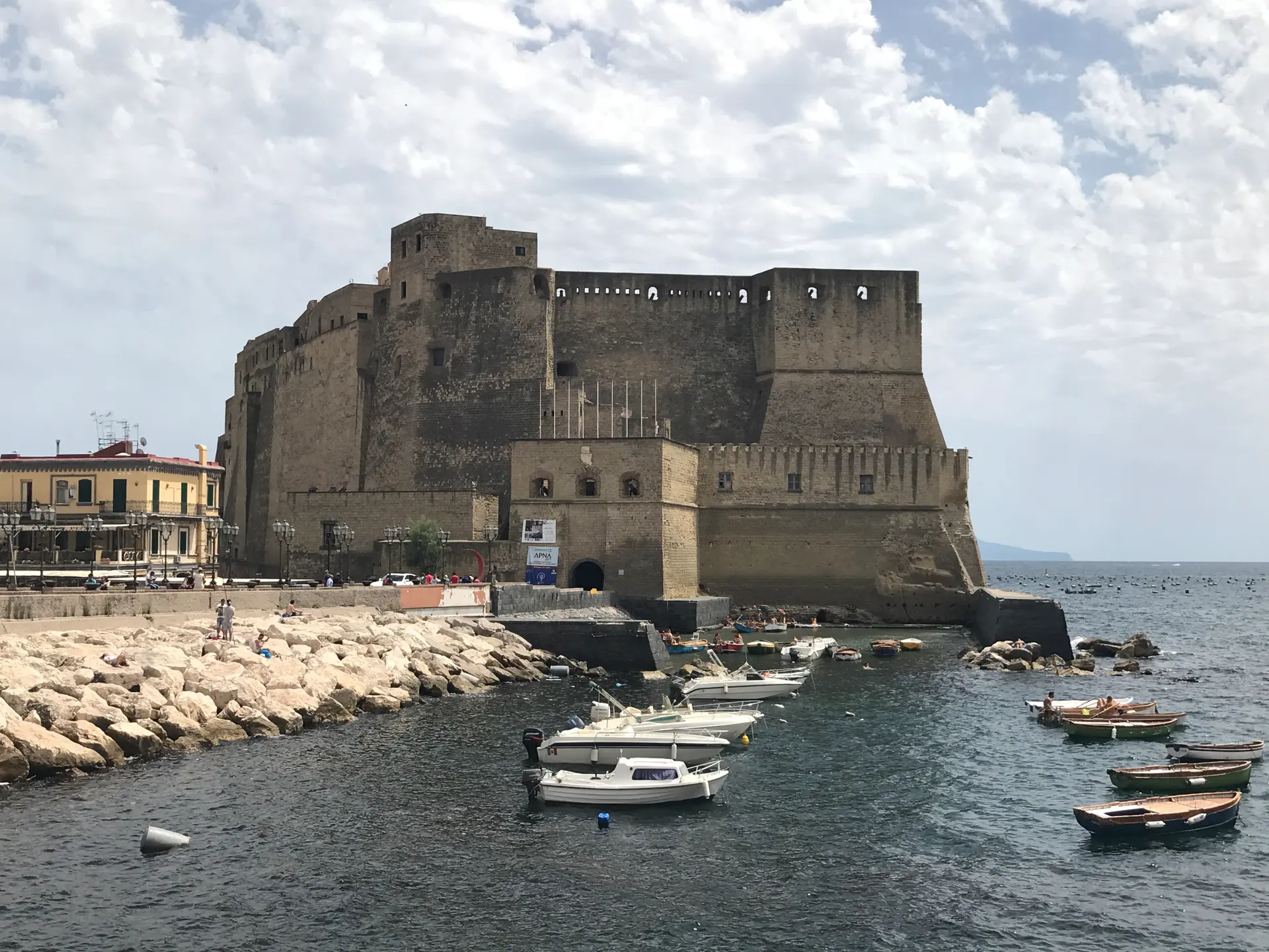 Small boats moored below the walls of Castel dell'Ovo in Naples.