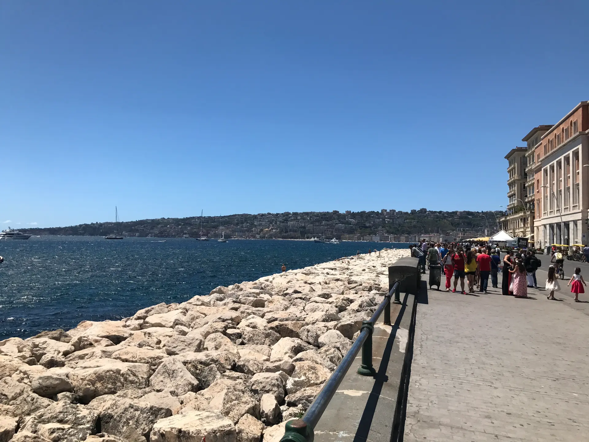 People walking the stone causeway out to Castel dell'Ovo in Naples.