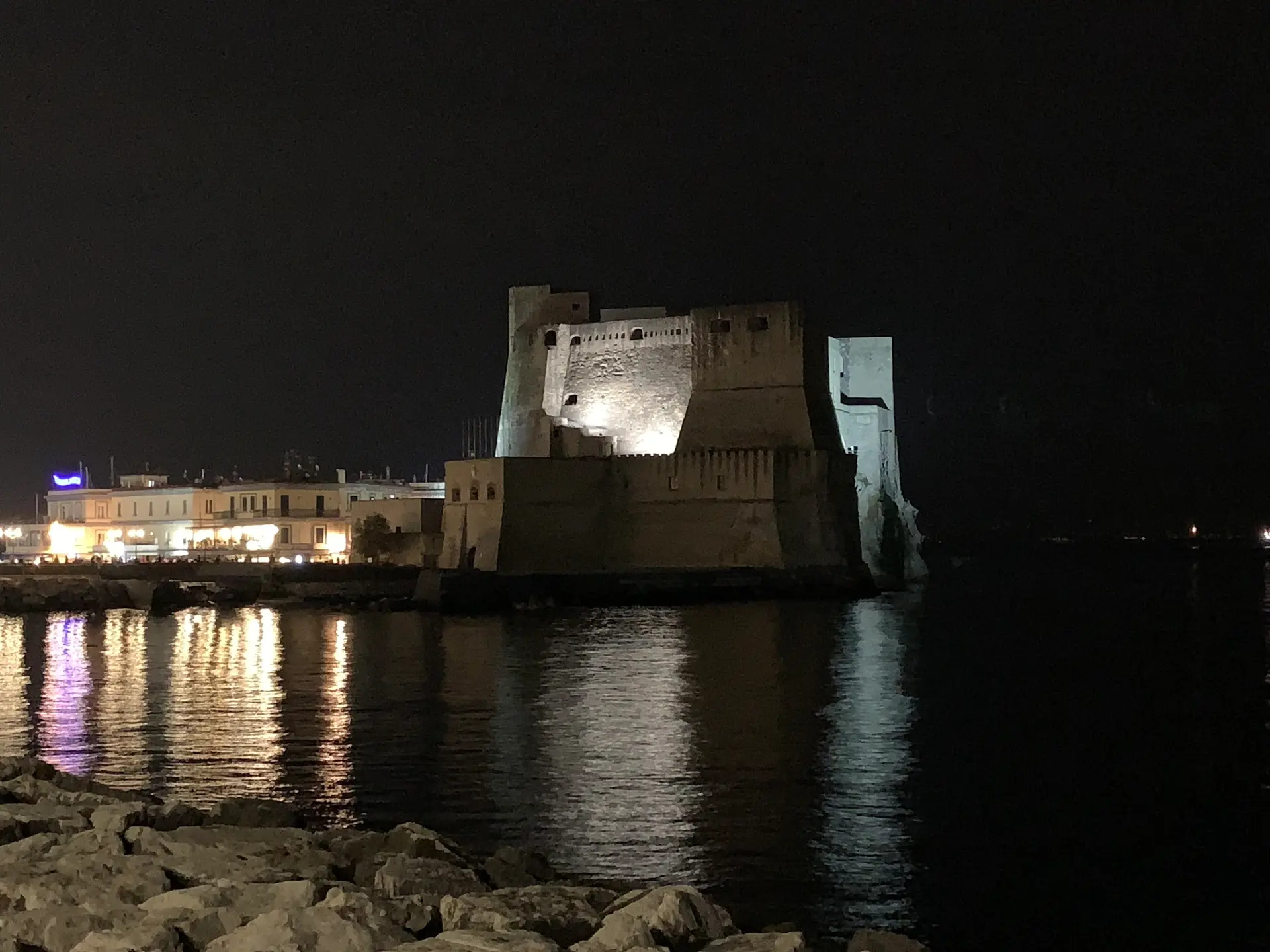 Castel dell'Ovo floodlit at night seen from the Santa Lucia side of the Naples seafront.