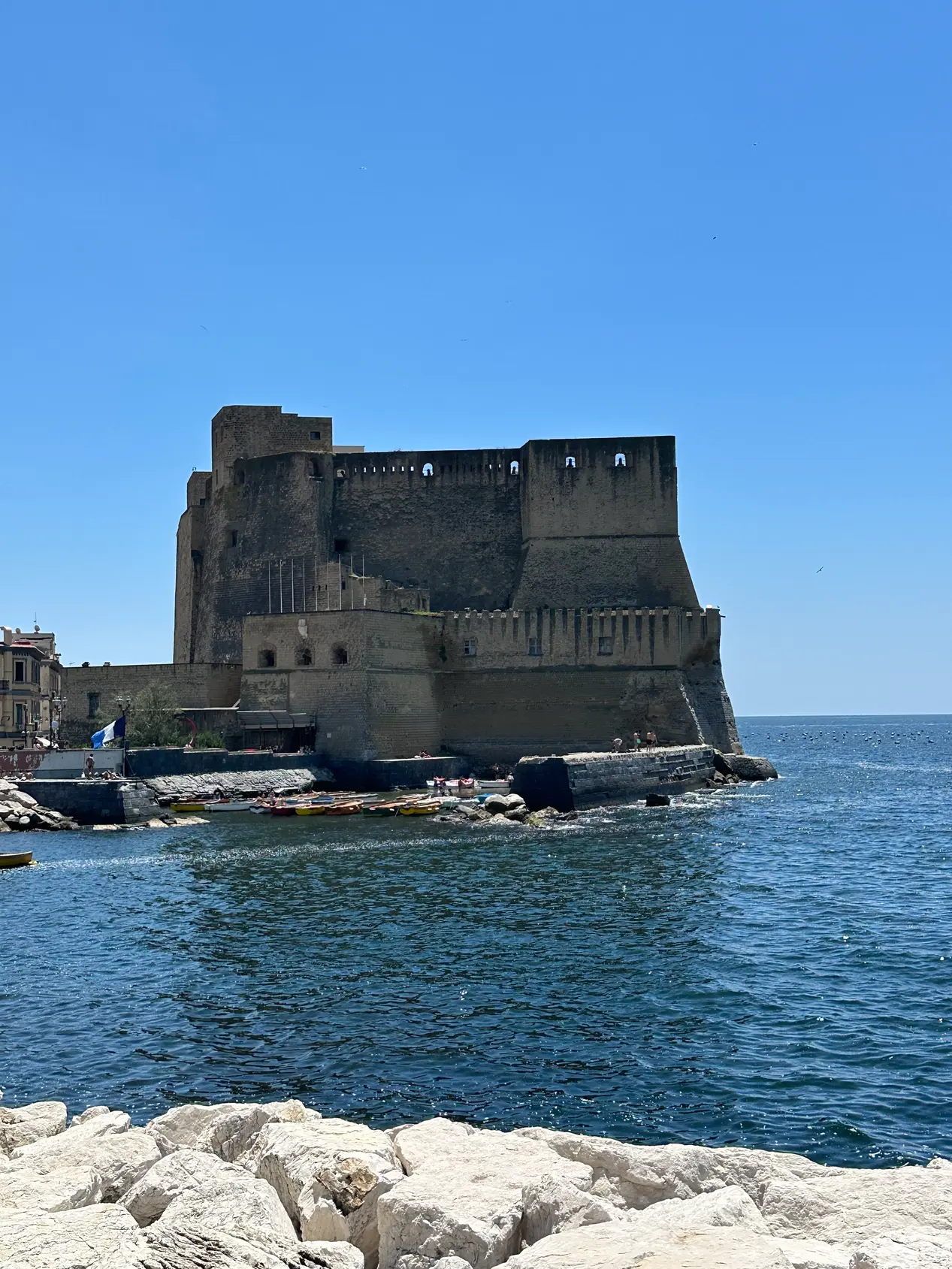 Castel dell'Ovo seen close from the rocks at the end of the Naples breakwater.