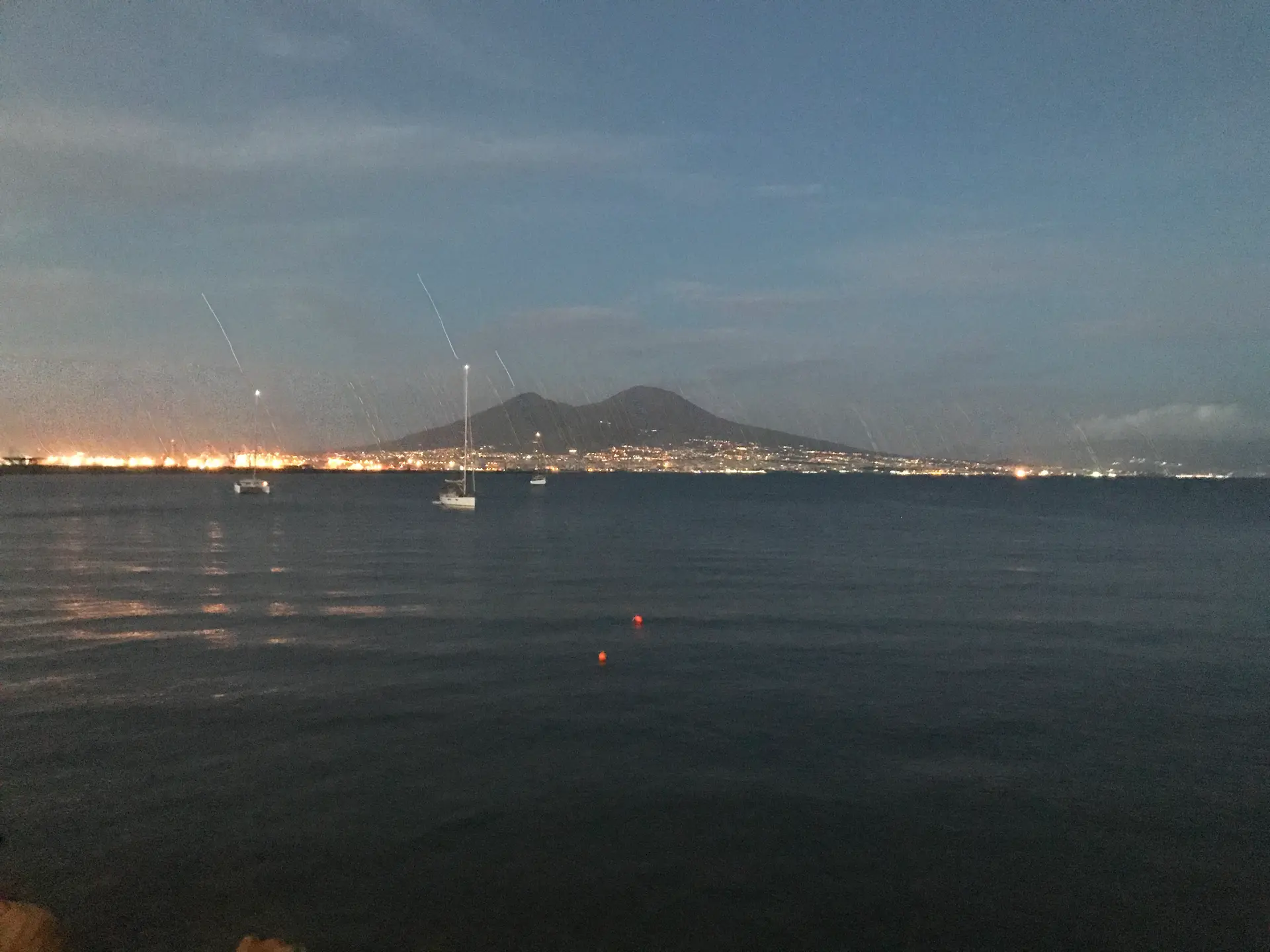 Mount Vesuvius at blue hour with the coastal towns lit along the Bay of Naples.