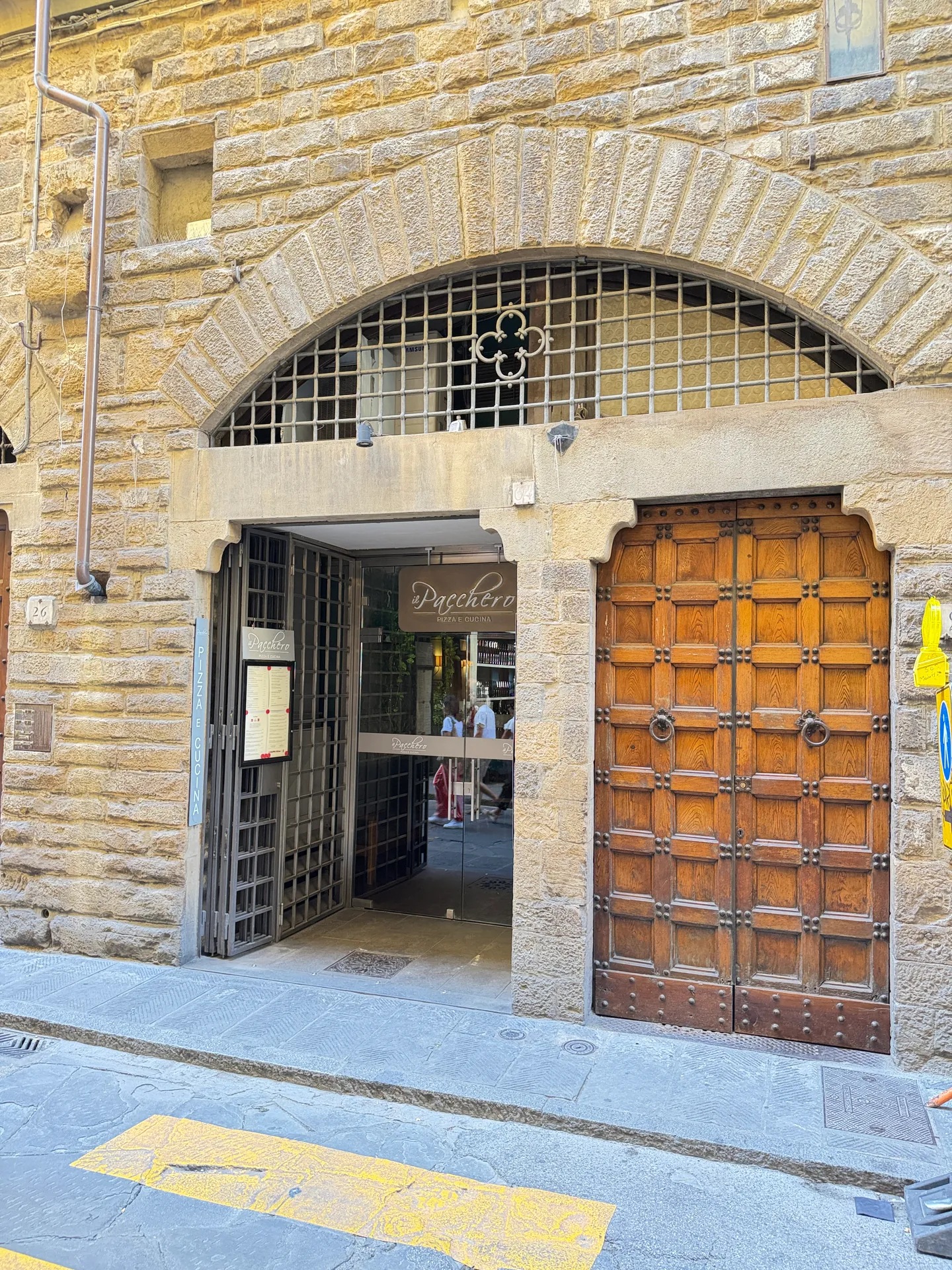 A wide stone arch over a workshop entrance, one leaf of the studded wooden door standing open.
