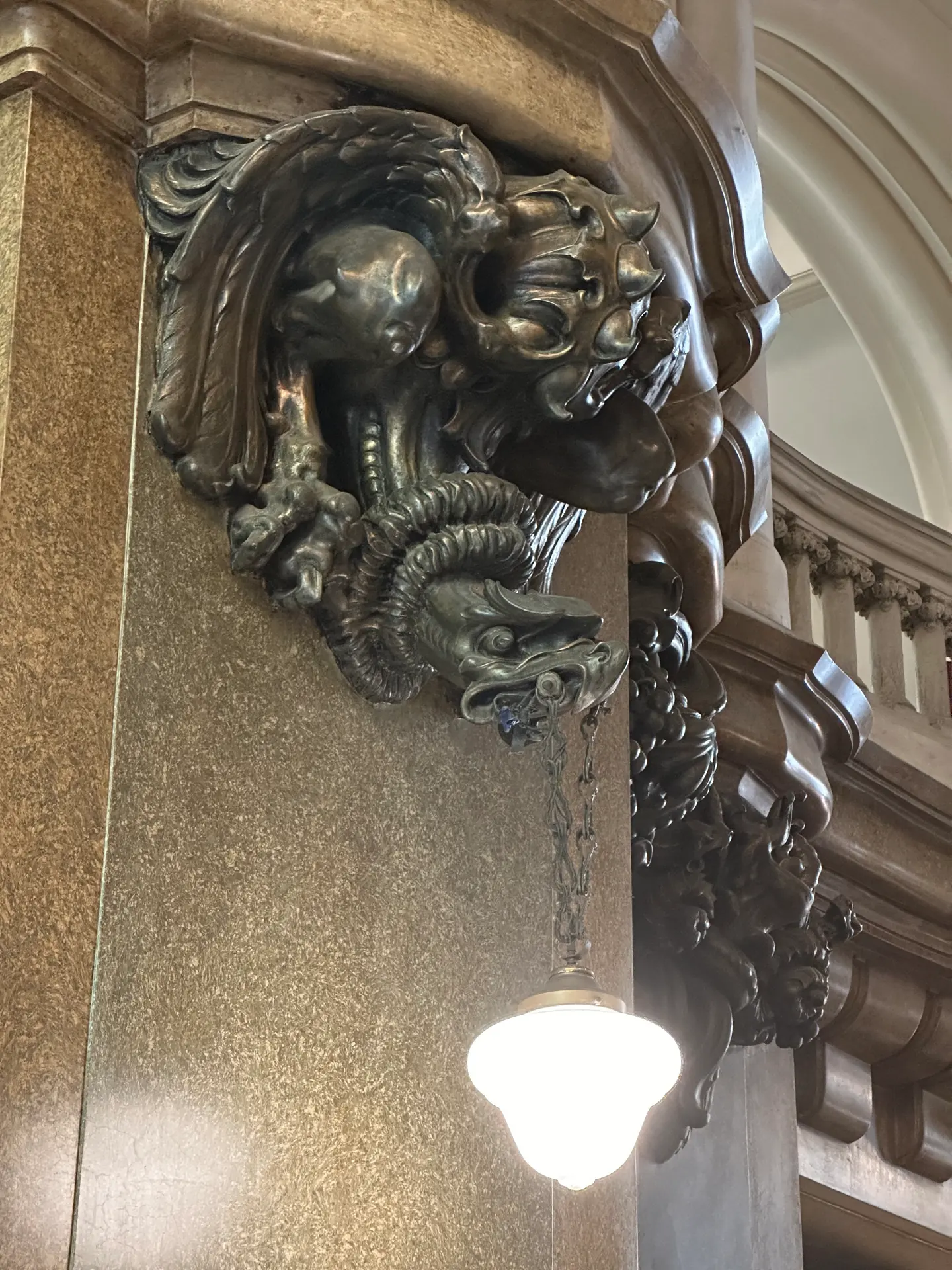 A carved winged griffin console supporting a lamp on a Buenos Aires facade.