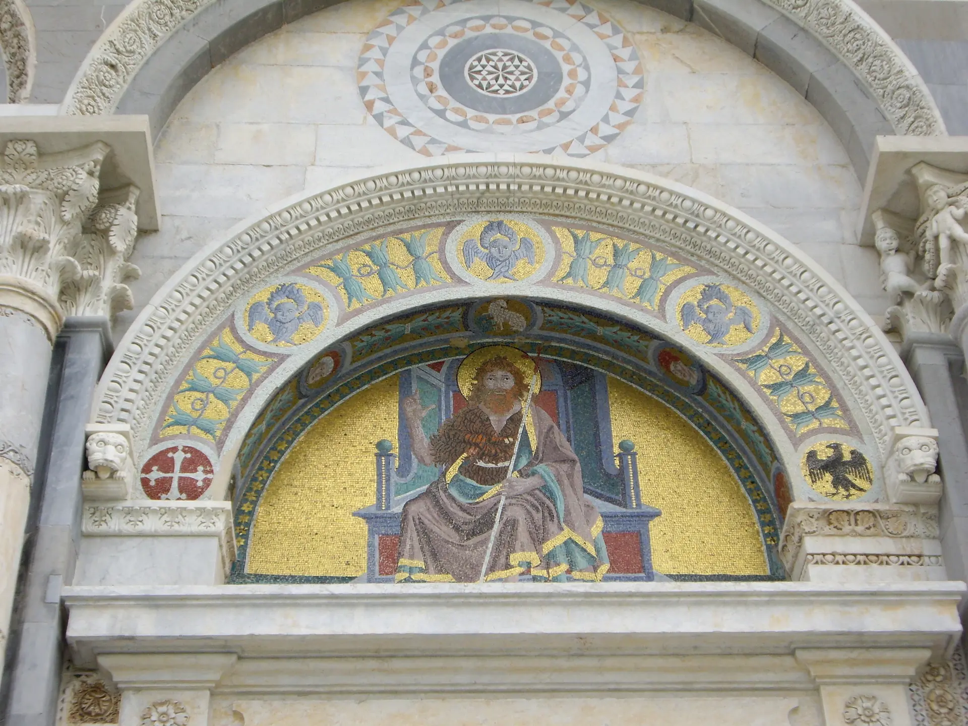 A gold mosaic figure enthroned in a lunette over a portal of Pisa cathedral