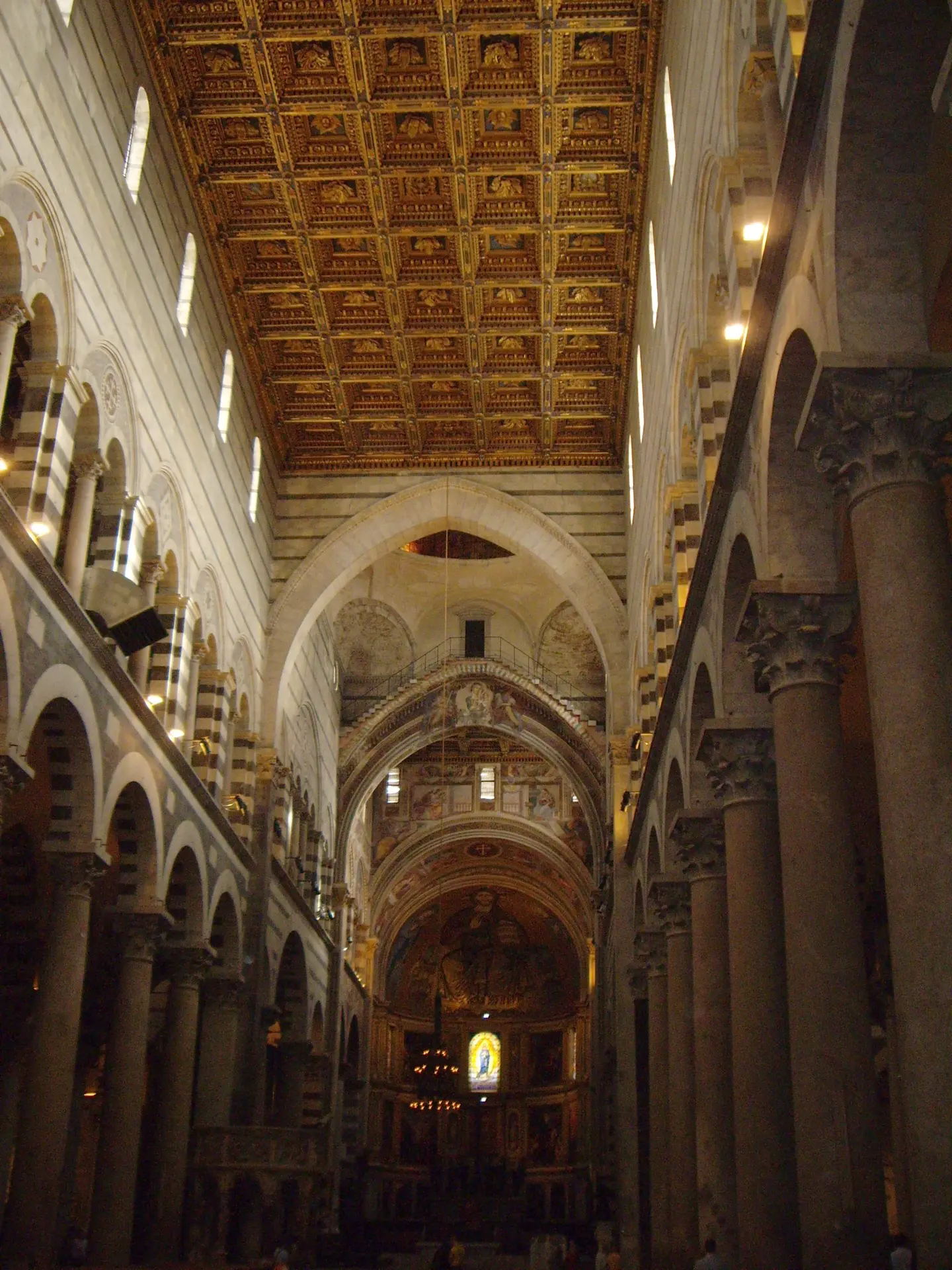 The nave of Pisa cathedral under its gilded coffered ceiling, looking toward the apse
