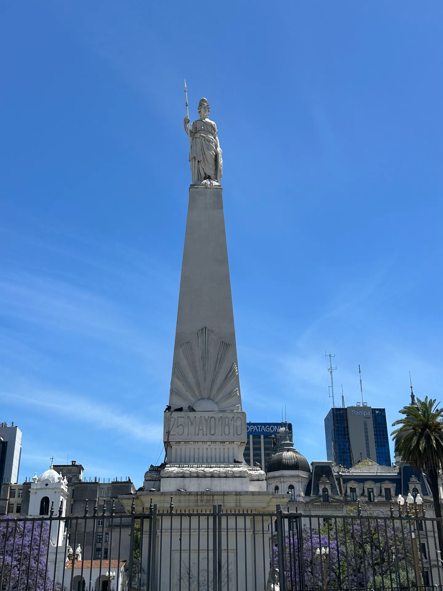 The white obelisk of the Piramide de Mayo against clear sky in Buenos Aires.