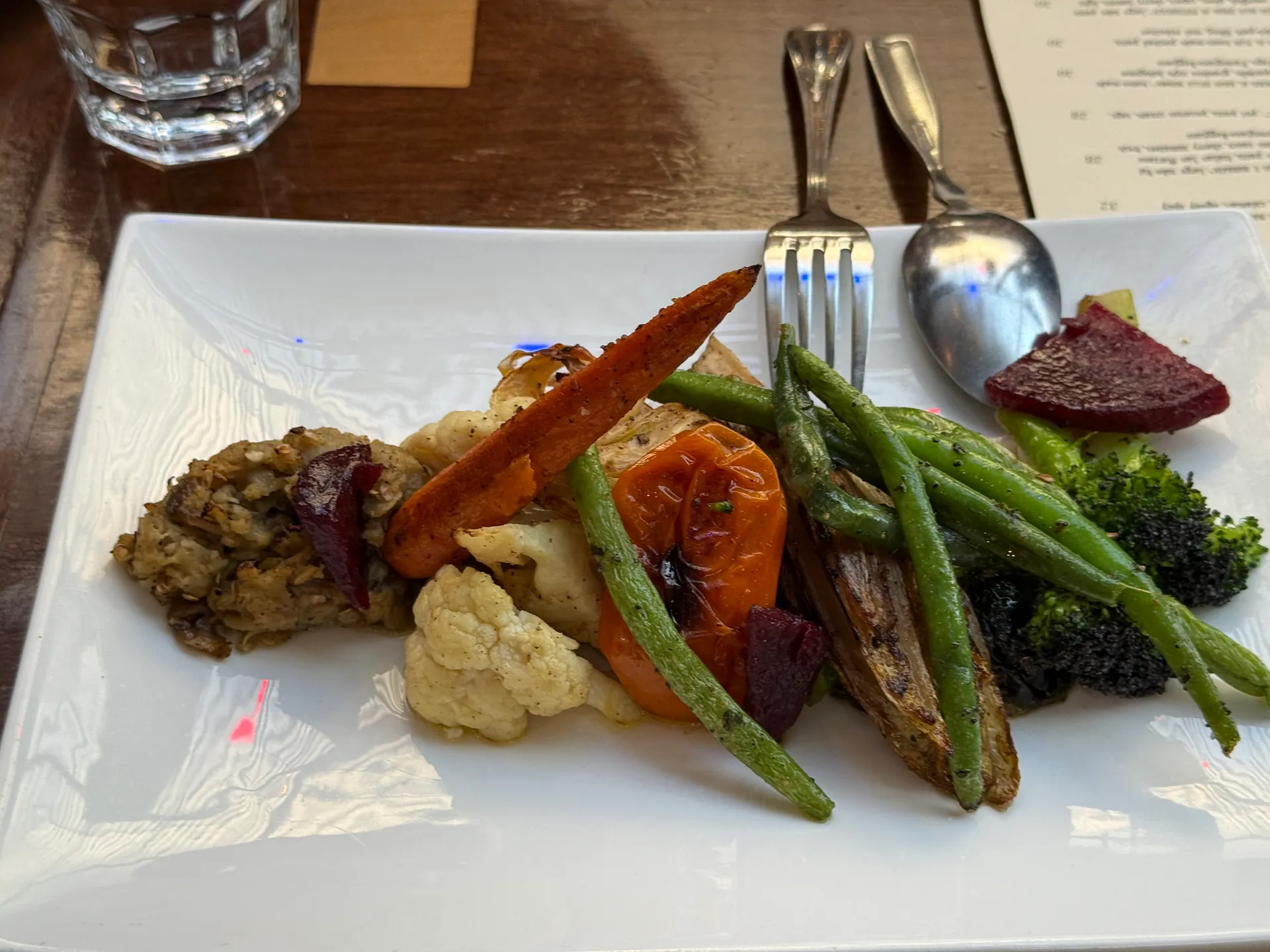 A plate of roasted vegetables including broccoli, green beans, cauliflower, carrot, and beet.