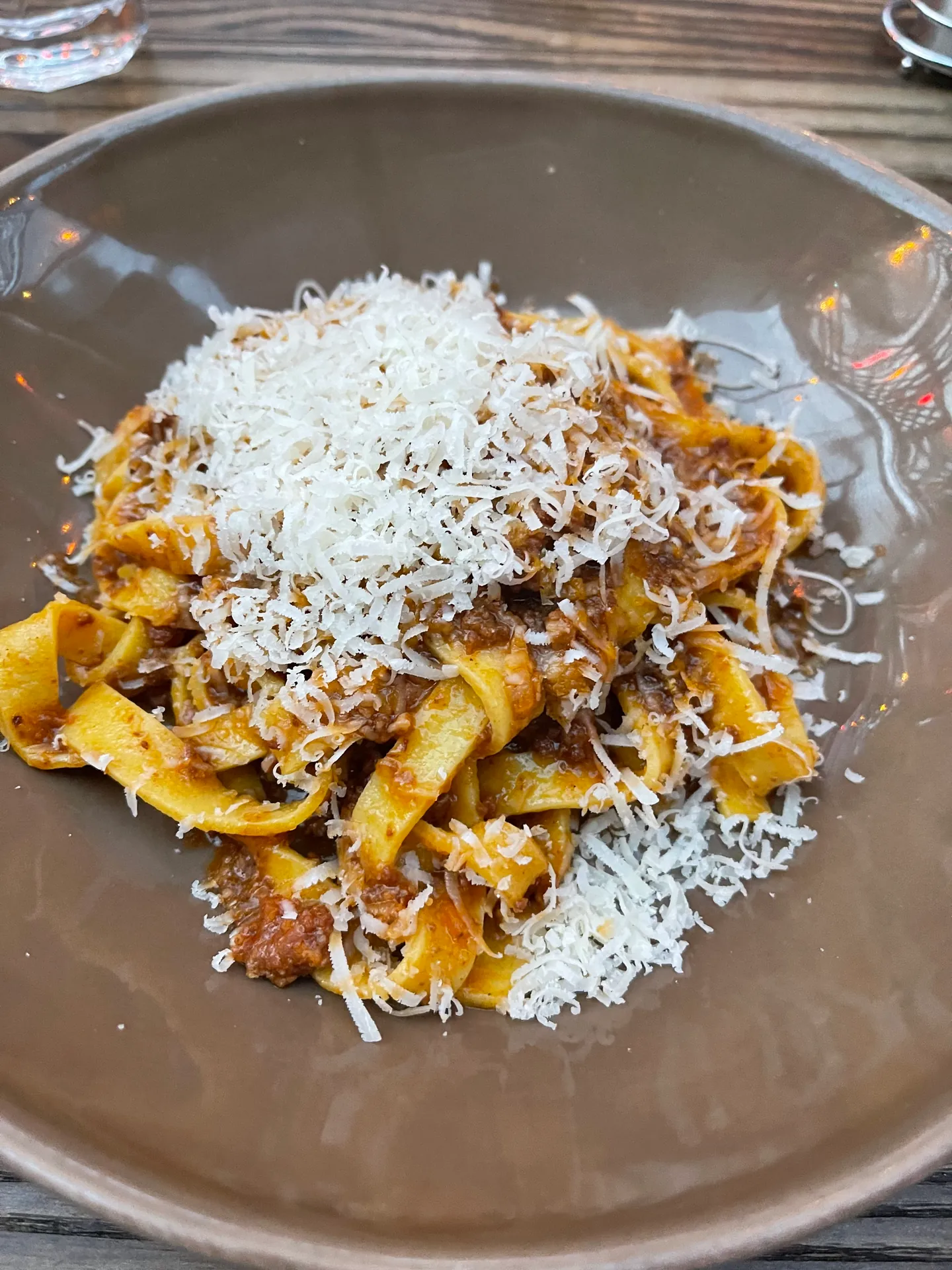 Ribbons of pappardelle in a brown meat ragu topped with grated cheese.