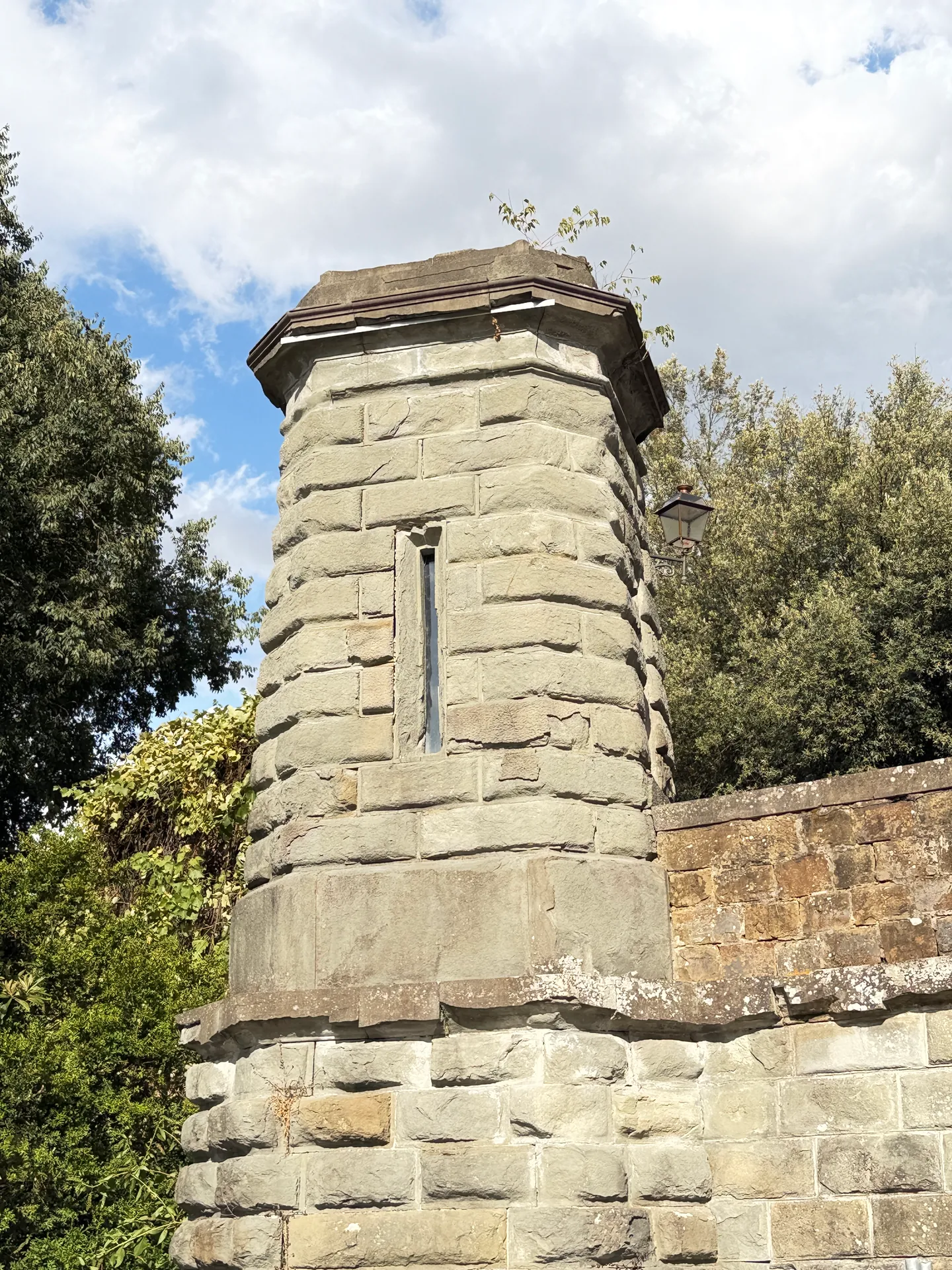 An octagonal rusticated pier standing on the parapet of the ramps, carrying an iron bracket.