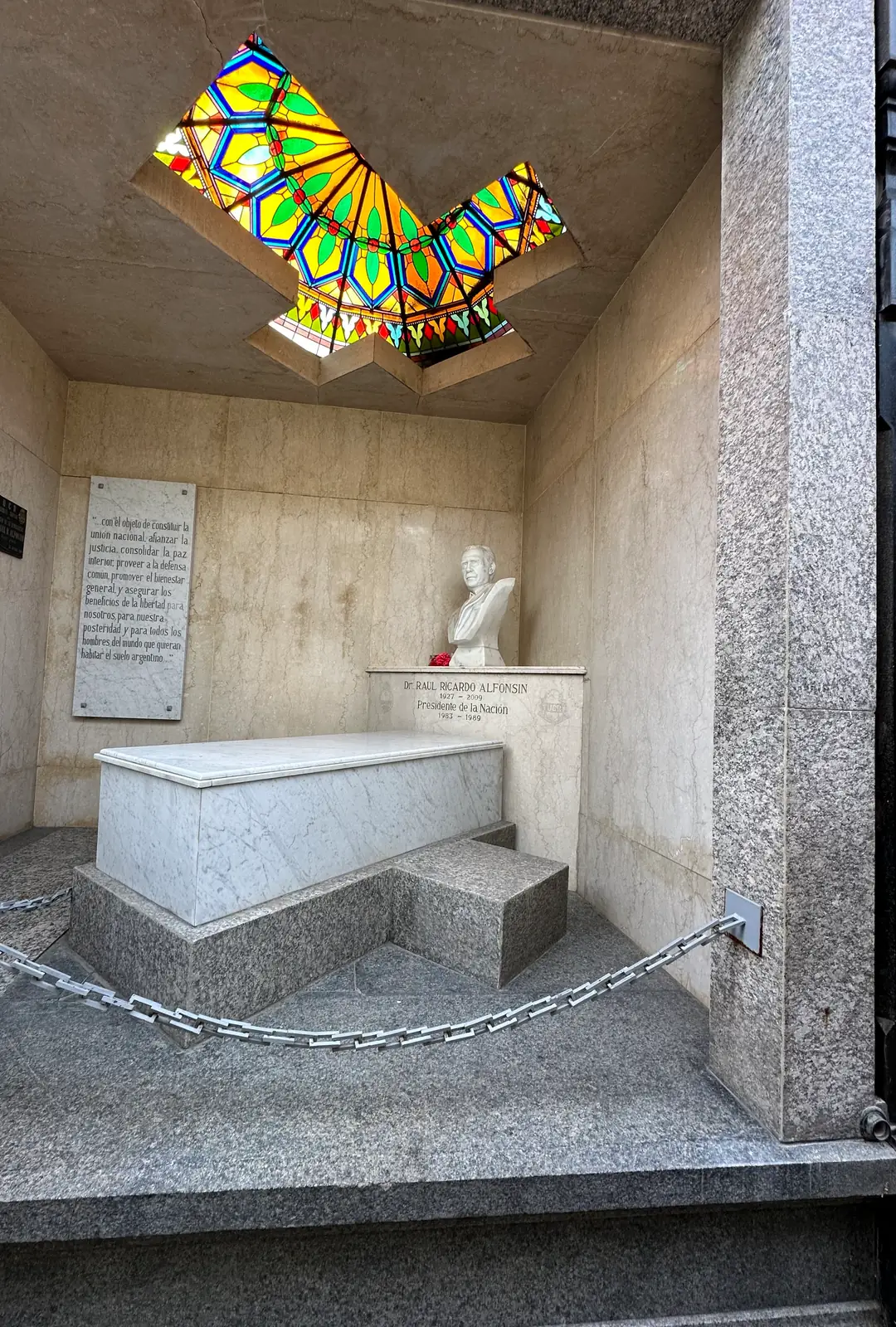The tomb of President Raul Alfonsin: marble sarcophagus, portrait bust and a stained glass skylight.