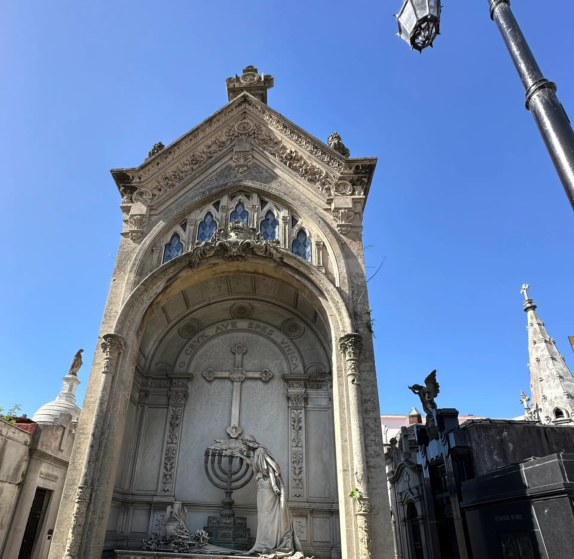 The neo-Gothic Dorrego Ortiz Basualdo mausoleum with a marble figure at a seven branch candelabrum.