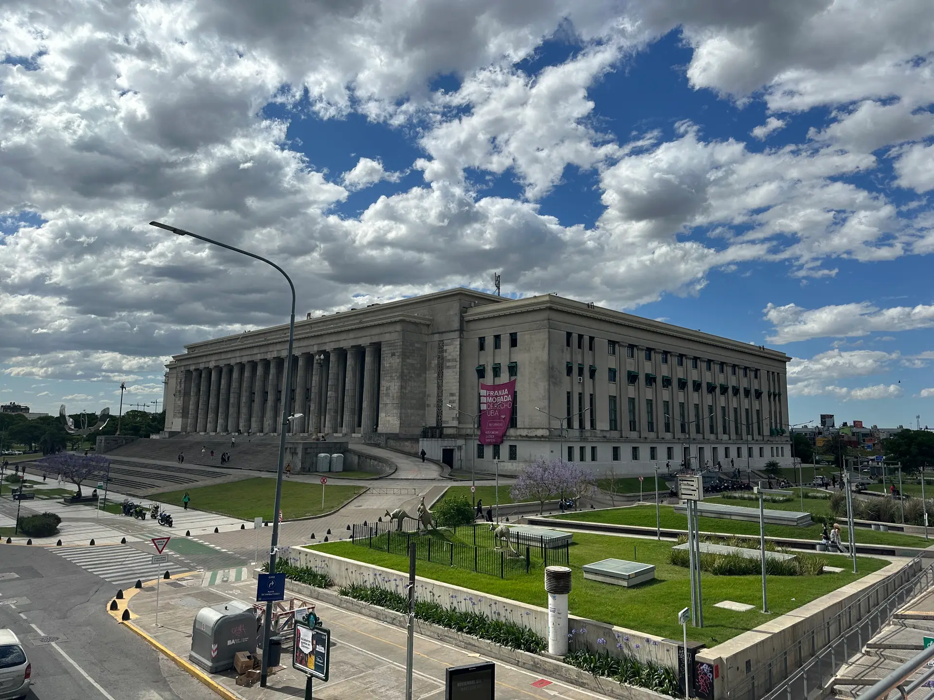 The monumental colonnade of the Buenos Aires law faculty under a dramatic cloudscape.
