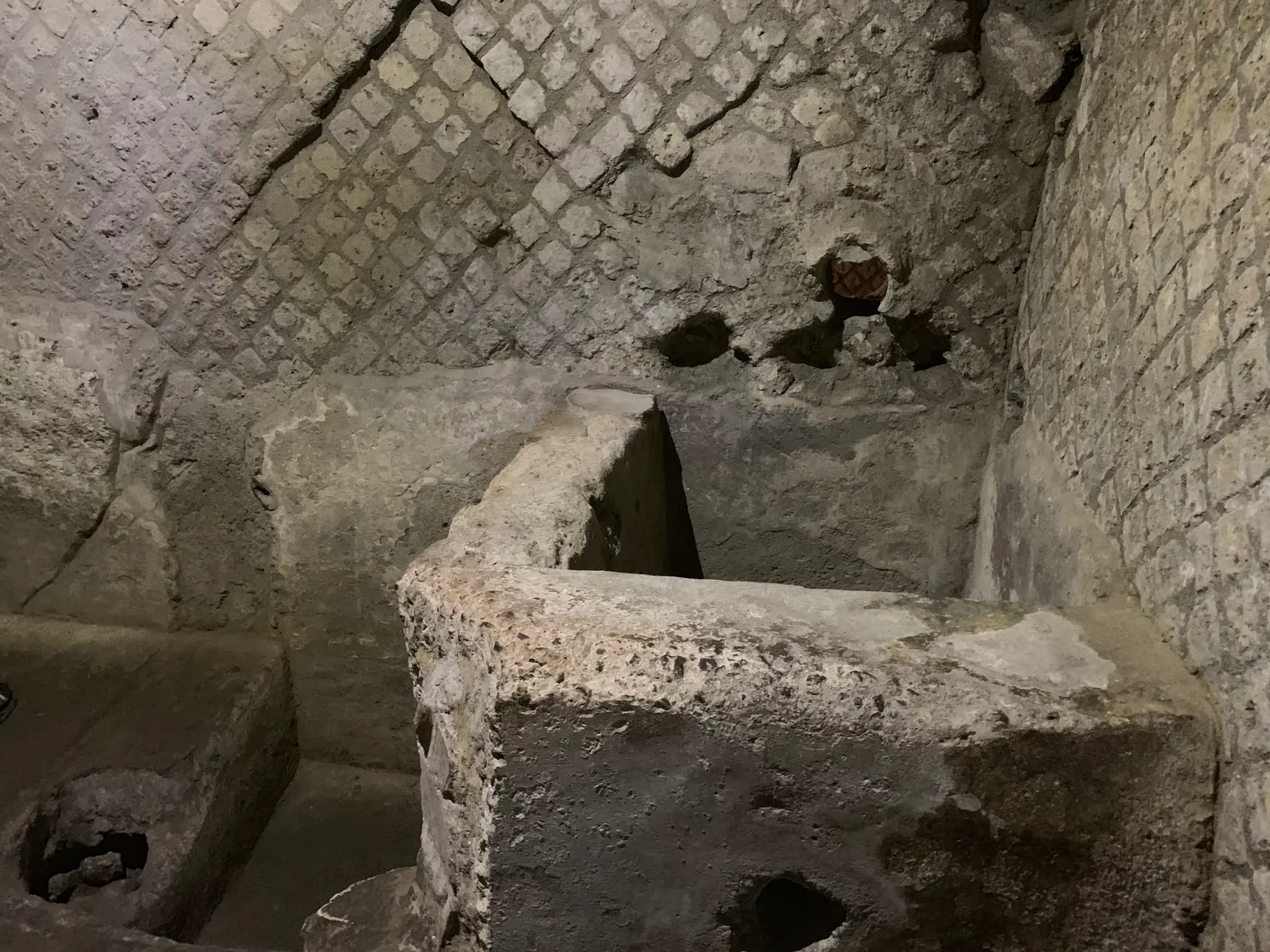 A masonry serving counter standing in a Roman shop below San Lorenzo Maggiore.
