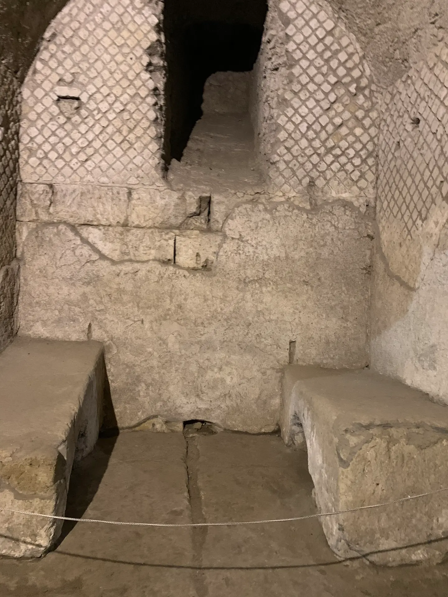 A masonry counter standing beneath a stone arch in a Roman shop in Naples.