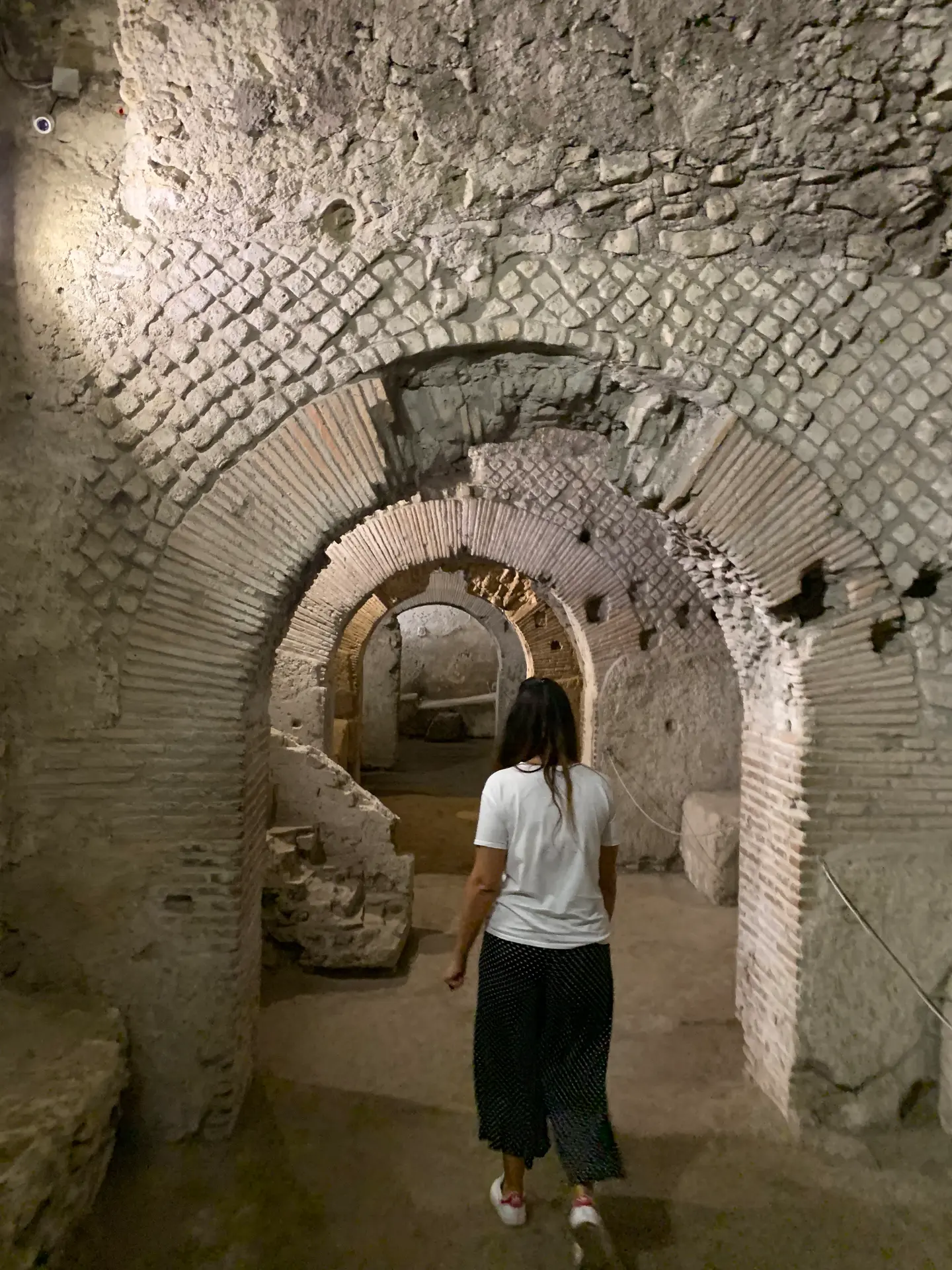 A line of brick-arched rooms running off the Roman market street in Naples.
