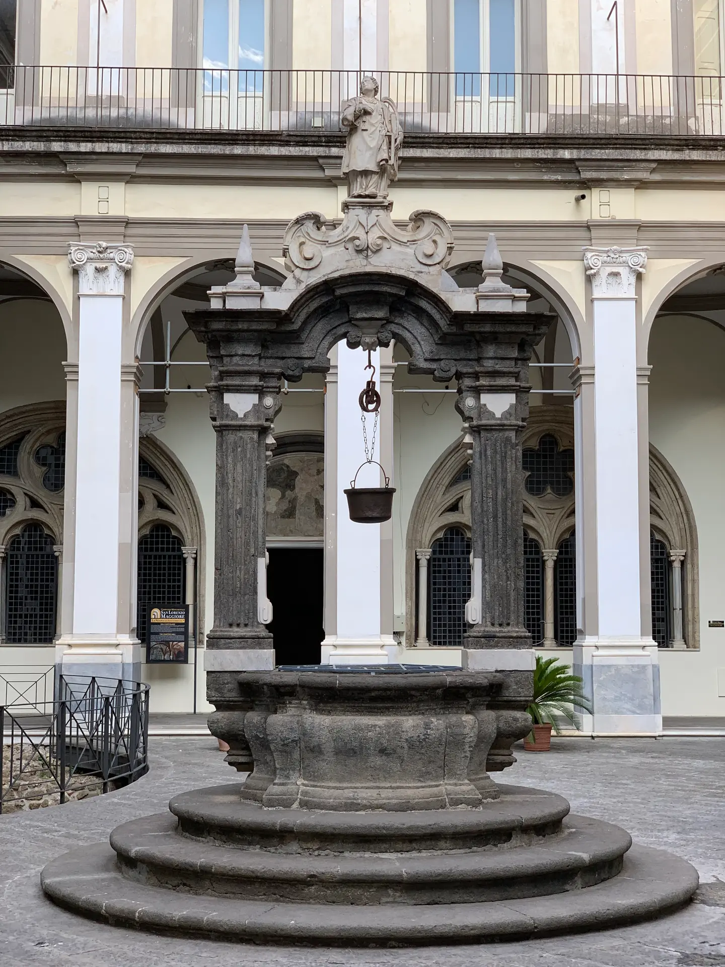 A stone wellhead in the arcaded cloister of San Lorenzo Maggiore, Naples.