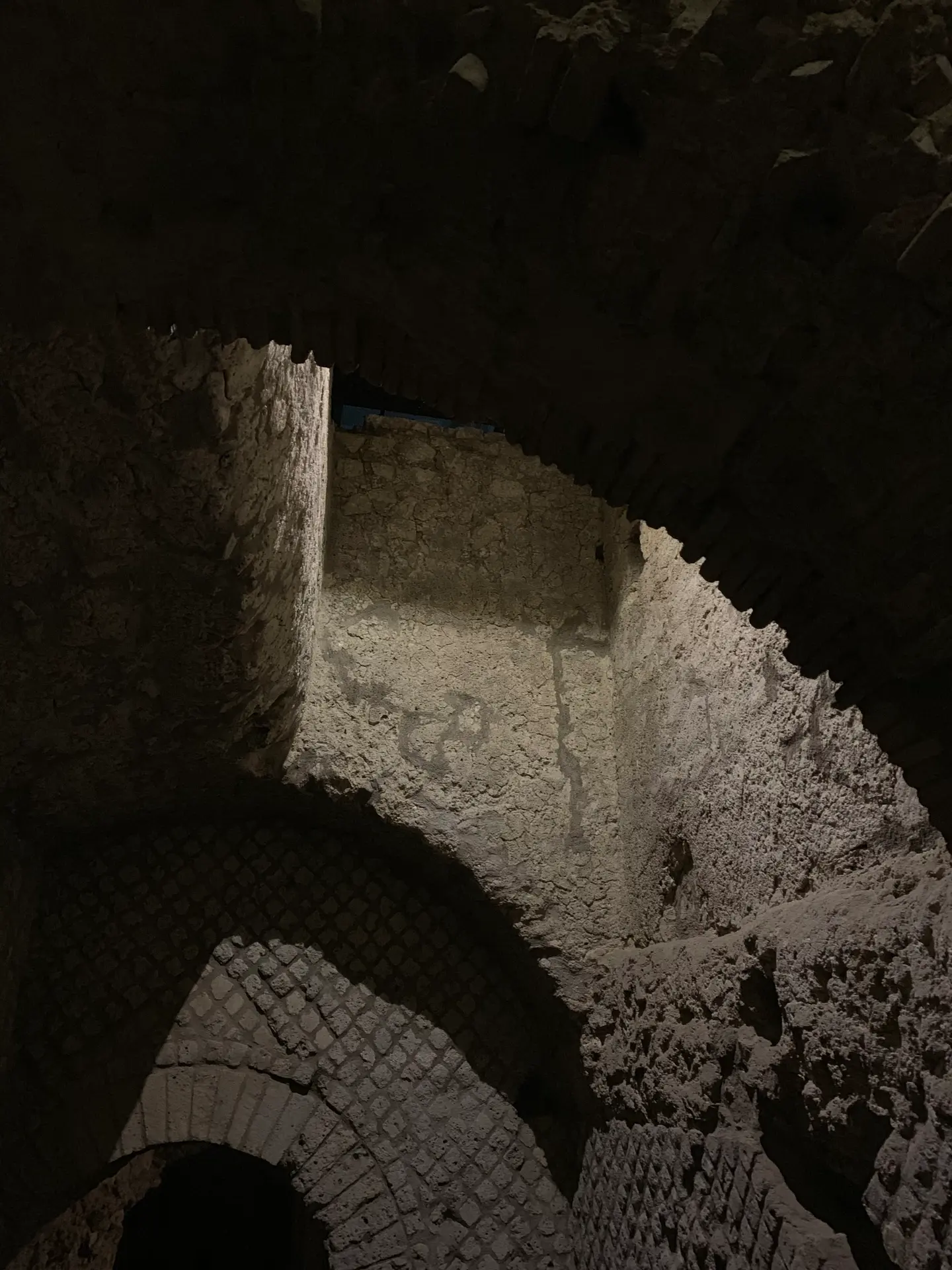 A Roman barrel vault springing from reticulate stone walls below Naples.