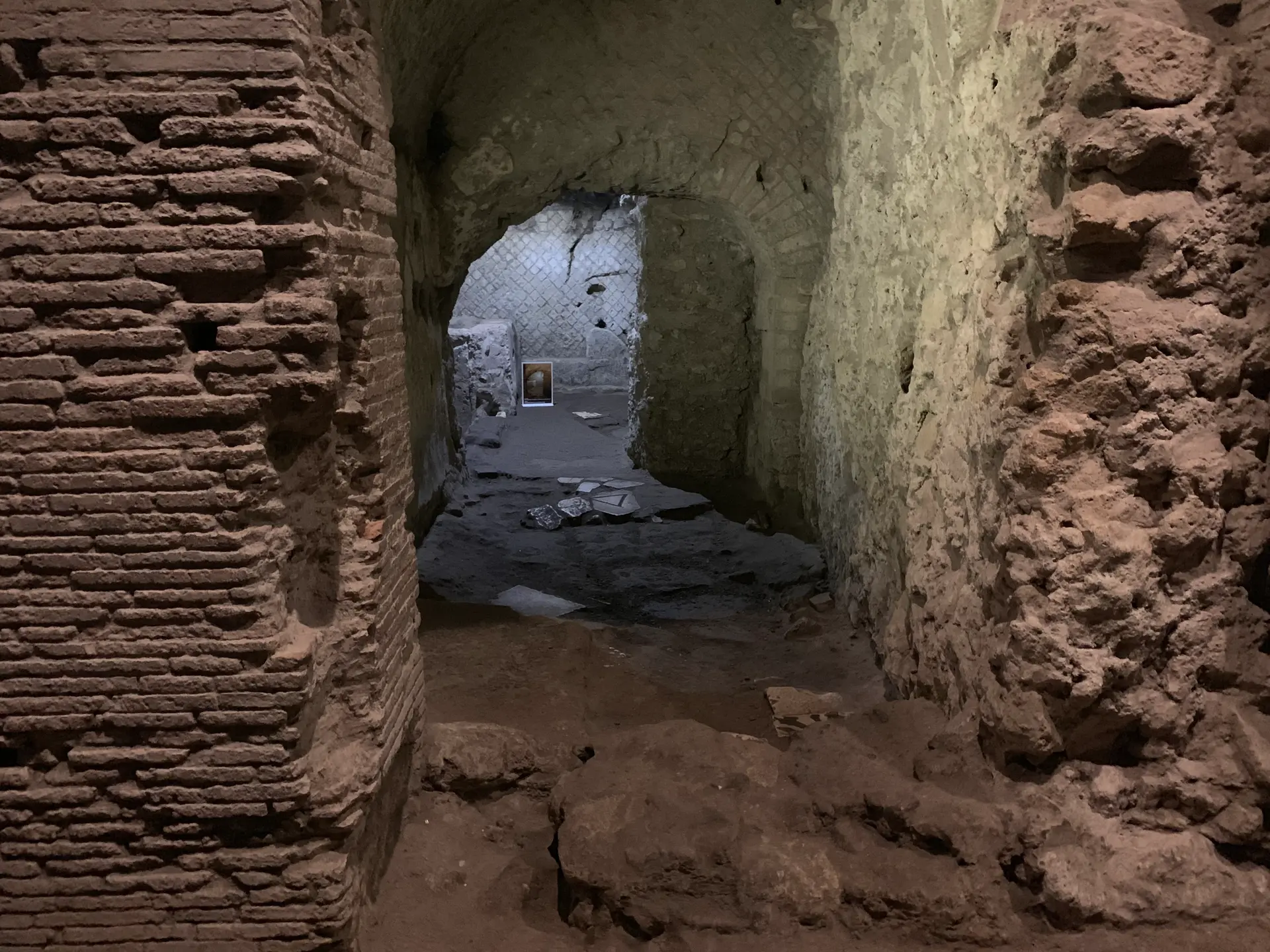 Two adjoining brick-vaulted Roman rooms opening off a market street in Naples.