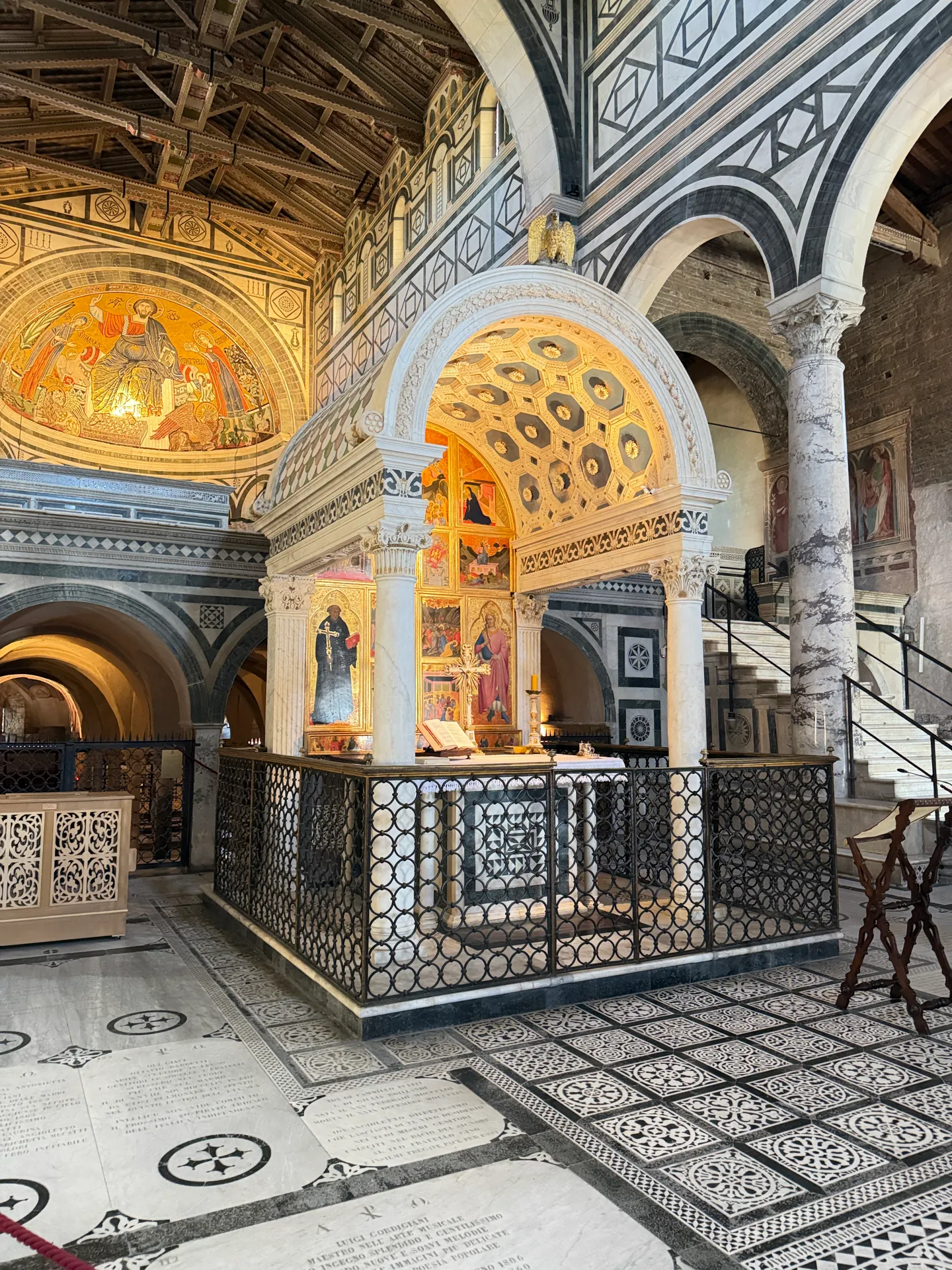 Michelozzo's free standing marble Chapel of the Crucifix in the nave of San Miniato, its iron enclosure around it.