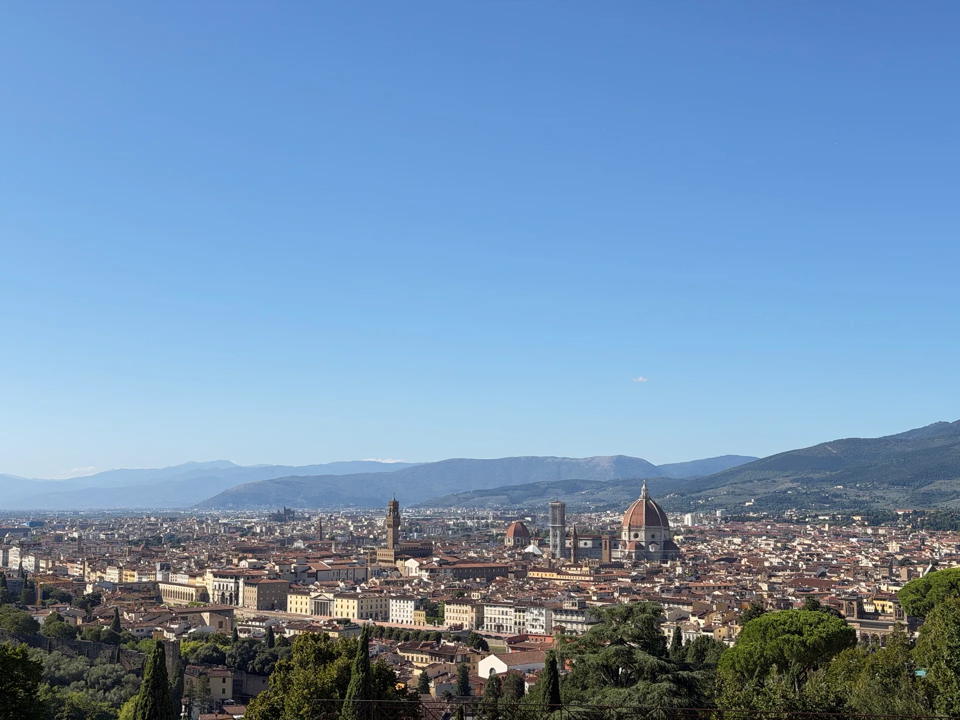 Florence seen from the terrace of San Miniato, the Duomo and the Palazzo Vecchio tower across the rooftops.